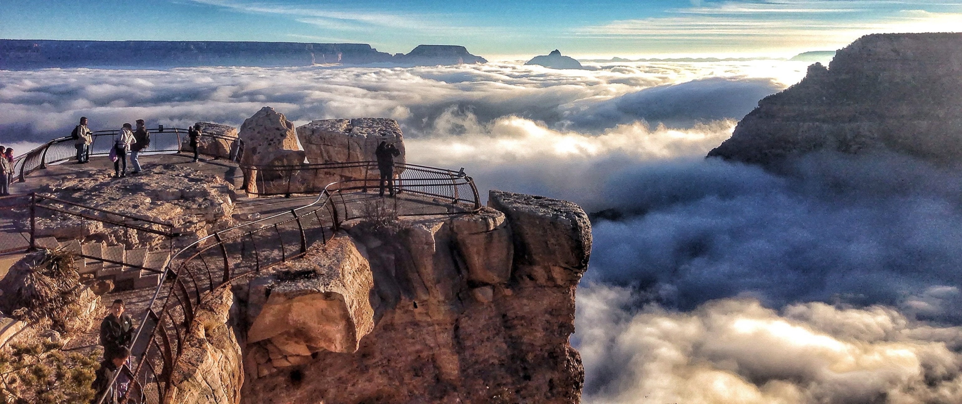 visitors at Mather Point at Grand Canyon National Park, Arizona, looking out over a rare total cloud inversion.