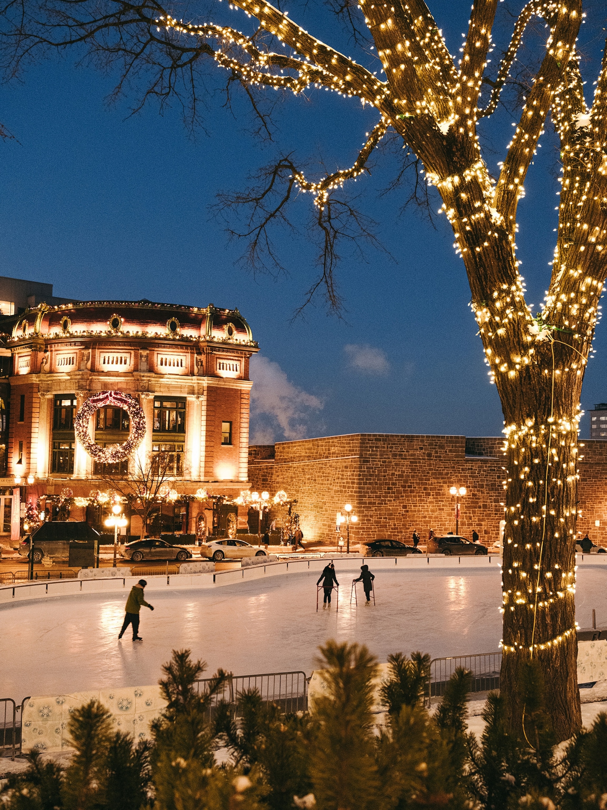 Skaters at Place D'Youville, a public square on one of the oldest roads in Quebec City in January 2025. For a livelier experience, about a 20-minutes' walk north at the Old Port of Quebec, one of Canada's largest ports, is a new nightclub-inspired skating rink called Discoglace.