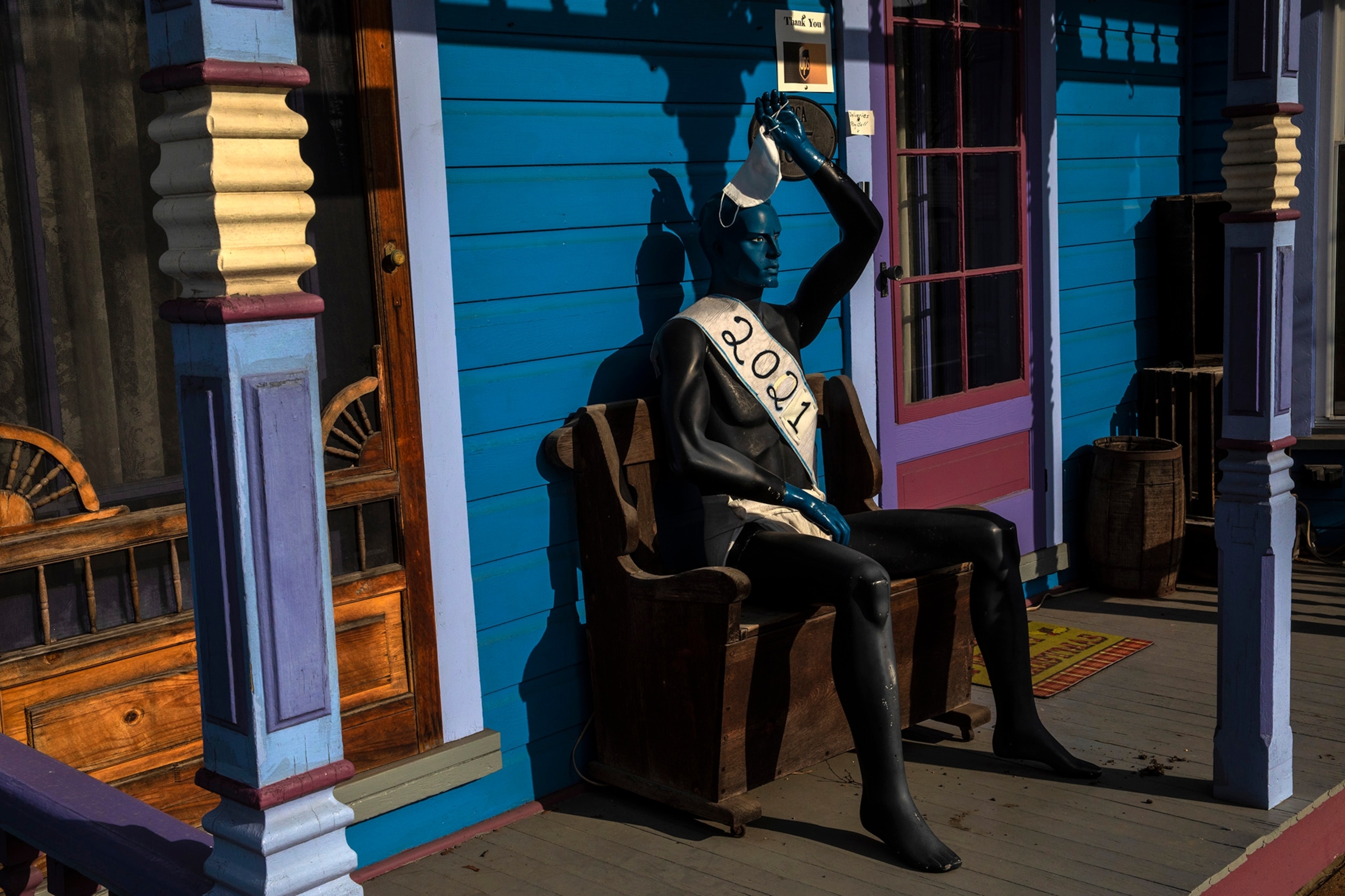 A seated blue mannequin with a 2021 sash