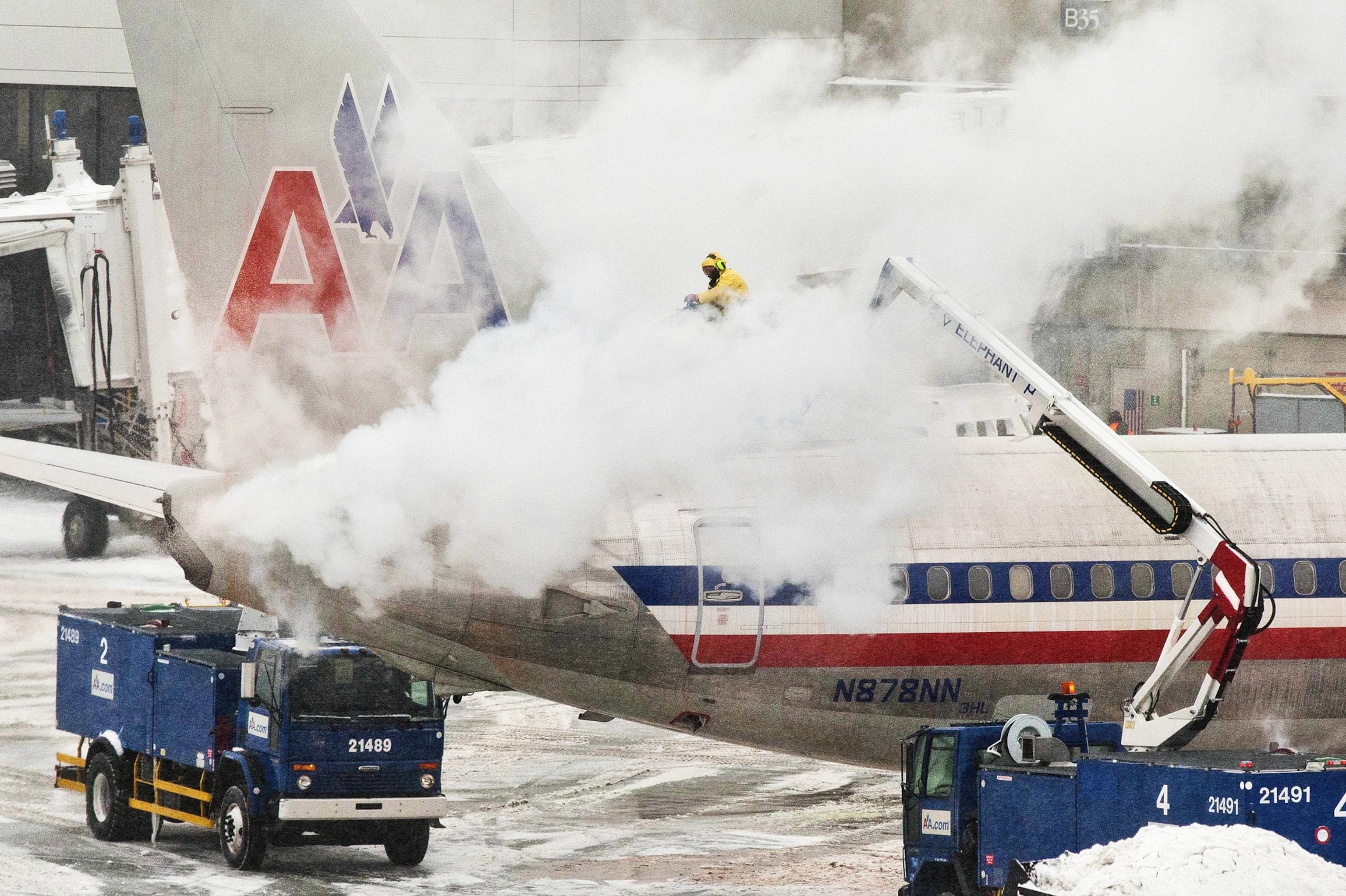 workers spraying de-icing solution on an airplane at Boston's Logan International Airport