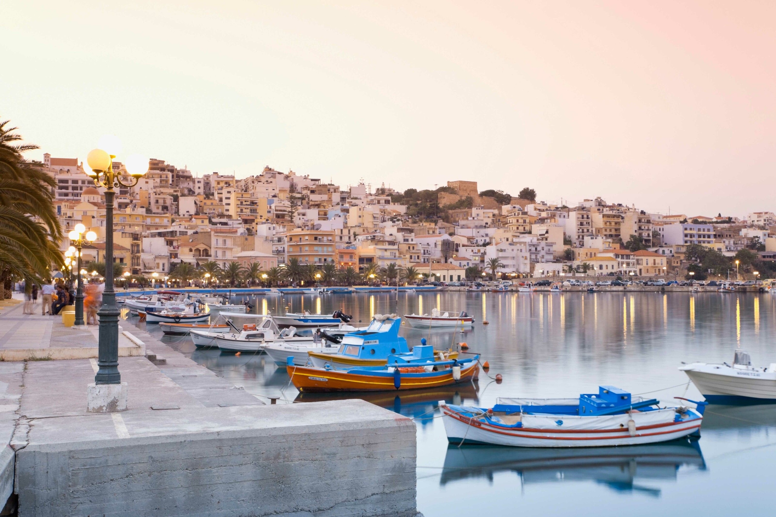 Boats moored at a small harbour at dusk.