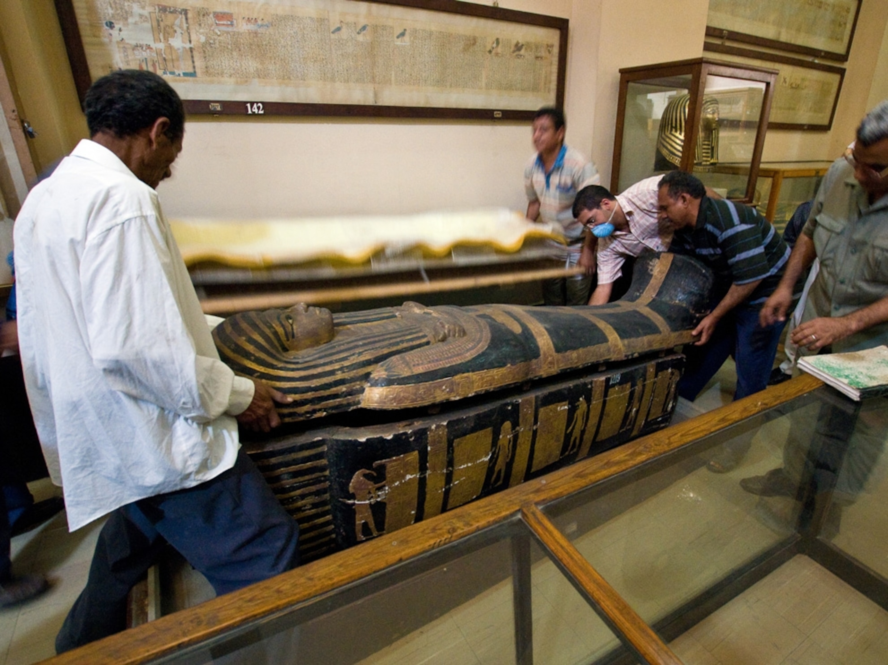 Egyptian mummy picture: Workers close a sarcophagus after scanning the mummy inside