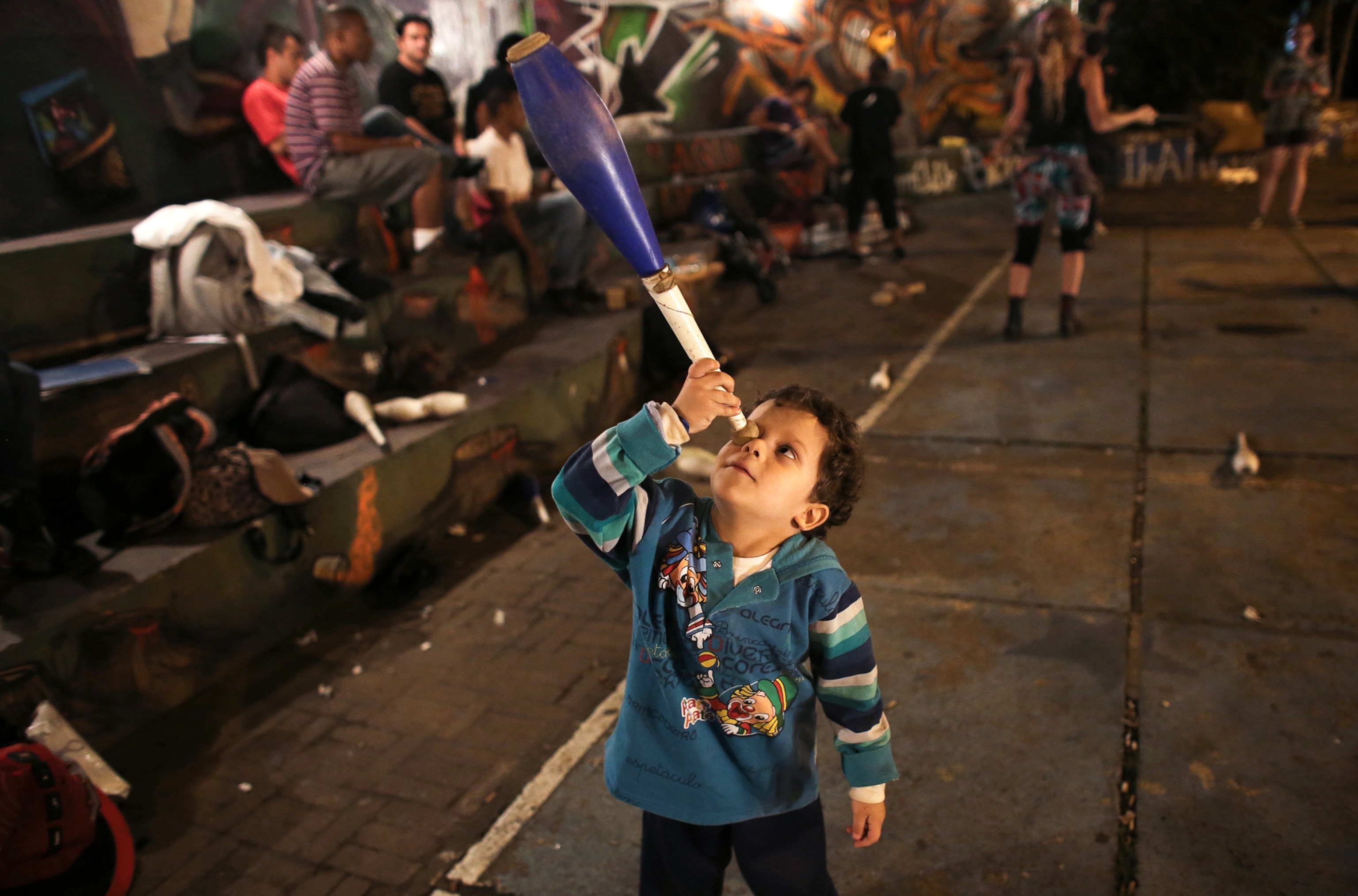 Circus of the Alley - A picture of a young boy playing with a juggling club in São Paulo, Brazil