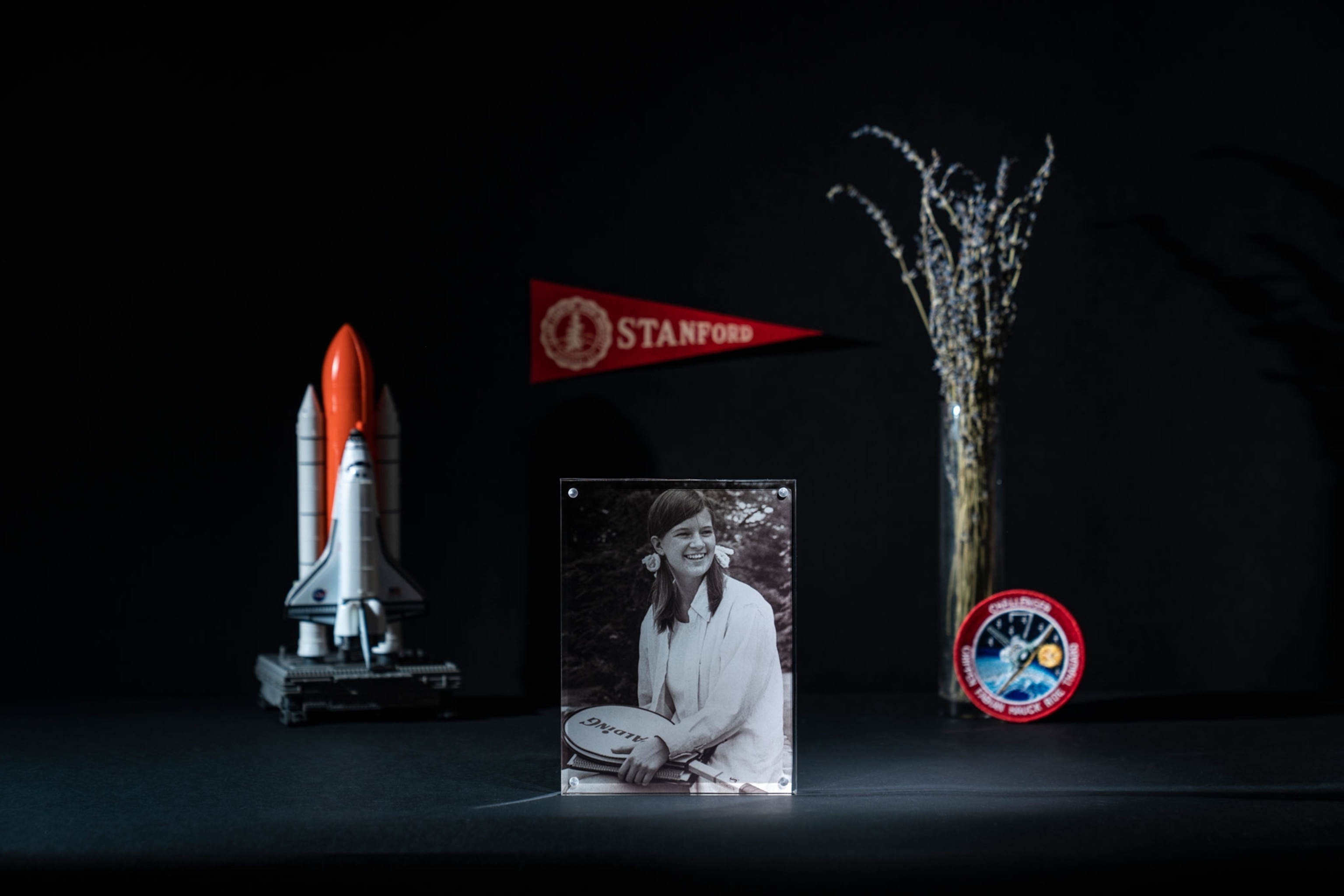 a portrait of sally ride as a 10th grader with a tennis racquet in a frame and memorabilia surrounding