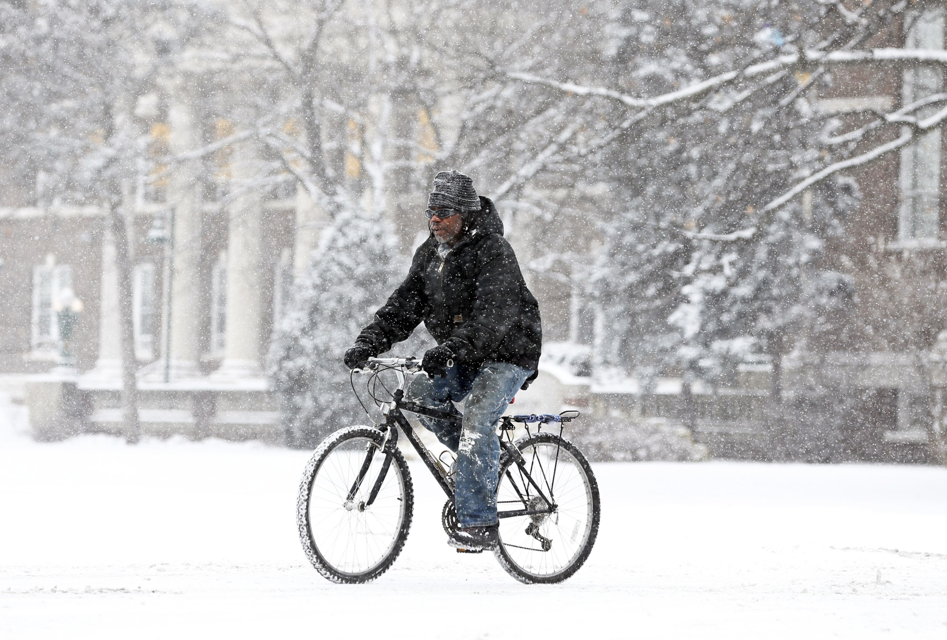 a man biking through the snow in Albany, New York, on Thursday
