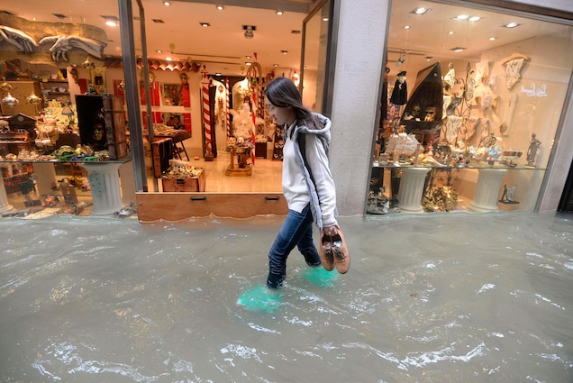 A woman walks in a flooded Venetian street. According to city officials, about 75 percent of the lagoon city was inundated in the 2018 floods.