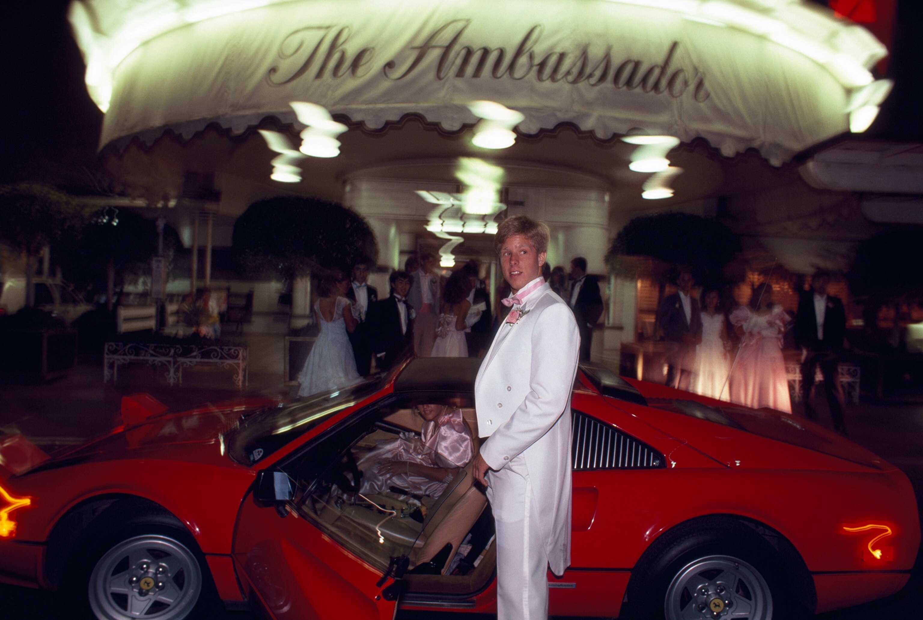 a prom couple getting out of their sports car