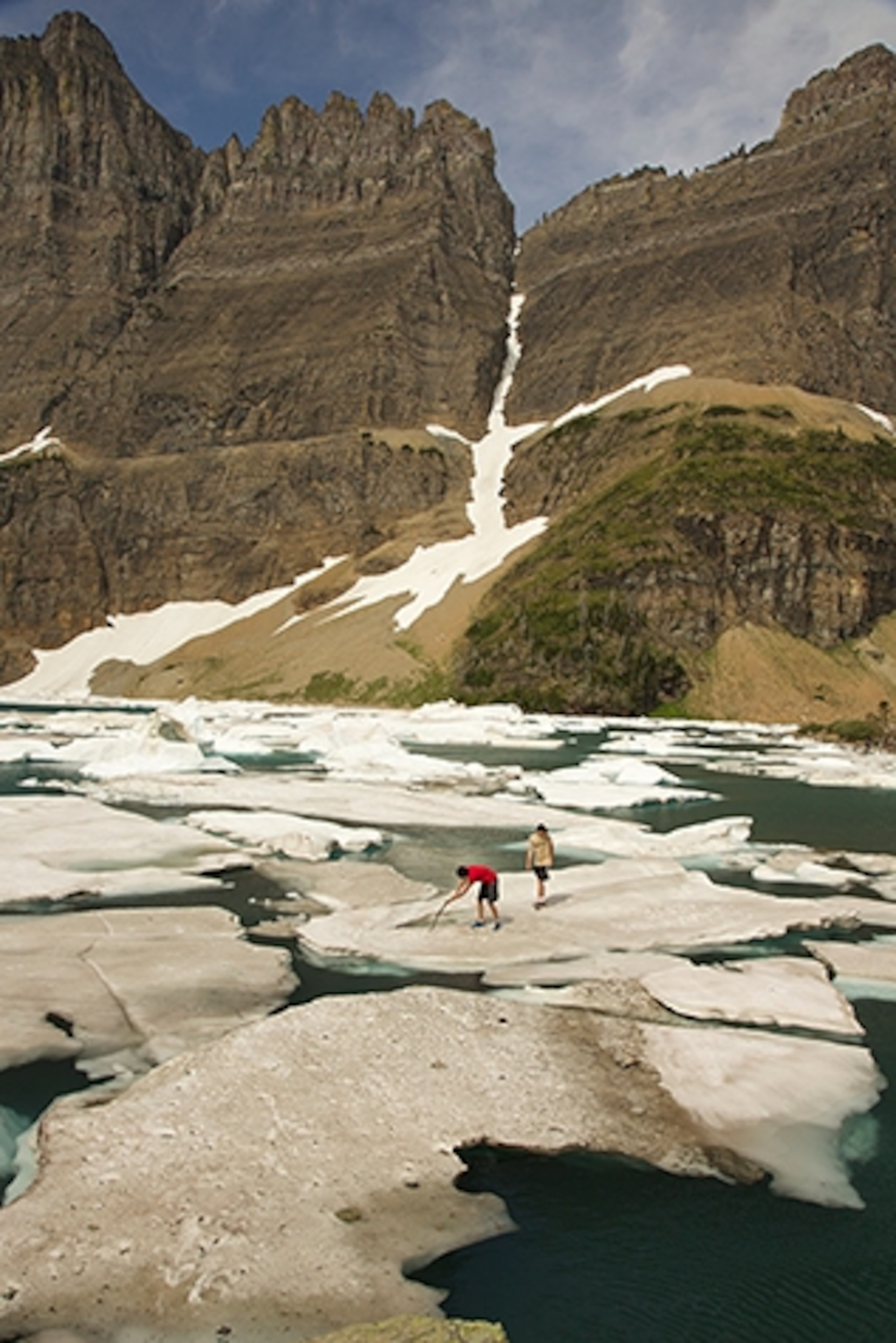 Gus and Jeb Kendrick stand on a block of floating ice at Iceberg Lake, Glacier National Park. (Photograph by Robb Kendrick)
