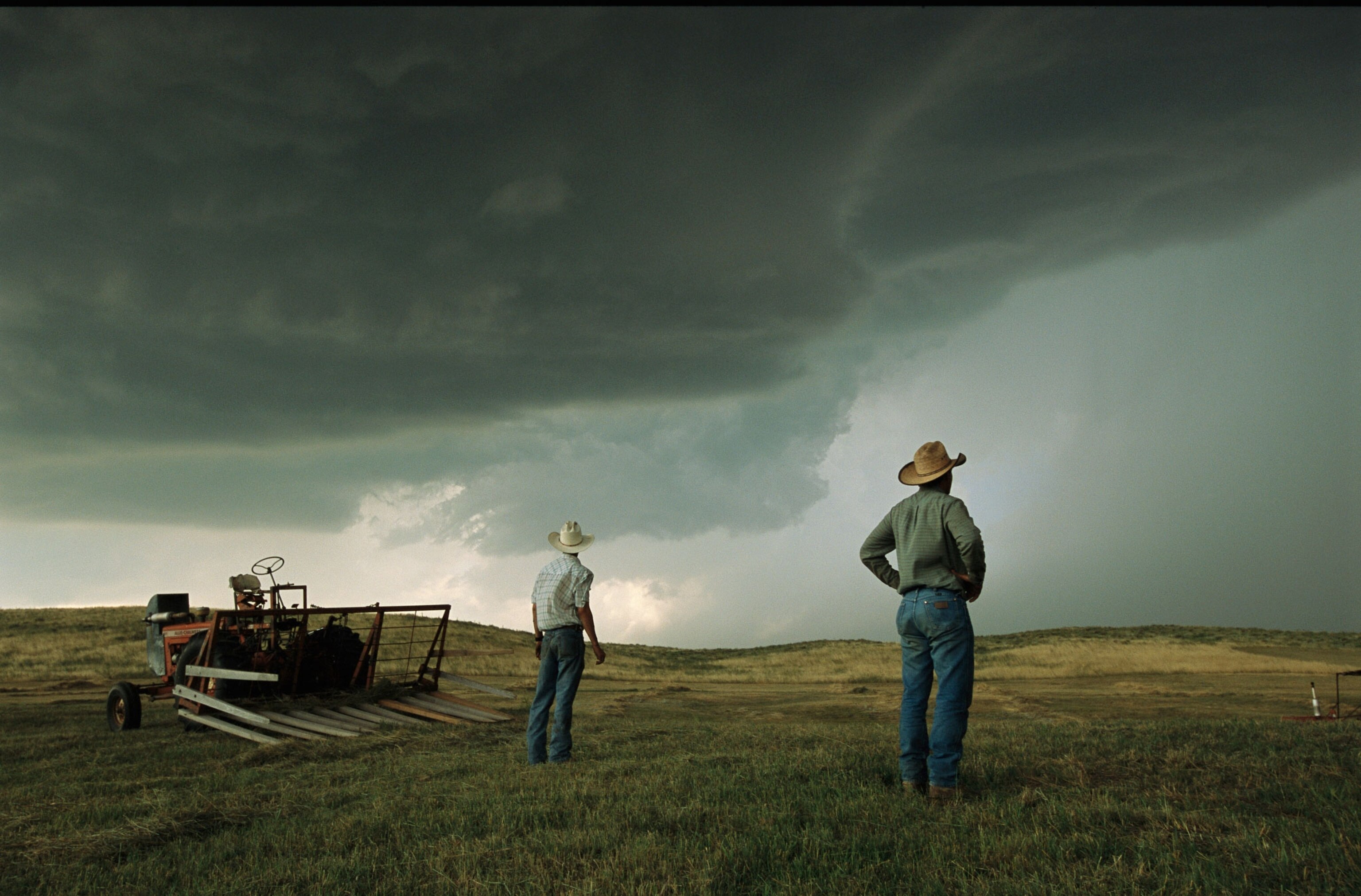 A thunderstorm halts haying as two farmers watch the sky, 2003.