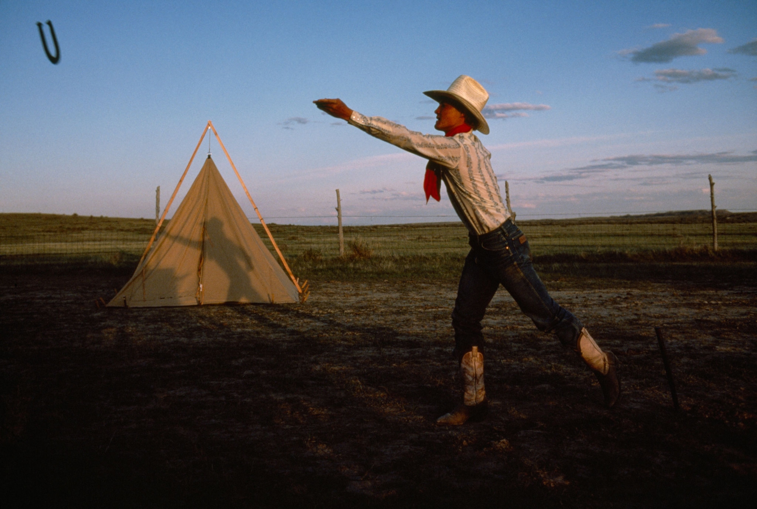 a cowboy throwing horseshoes