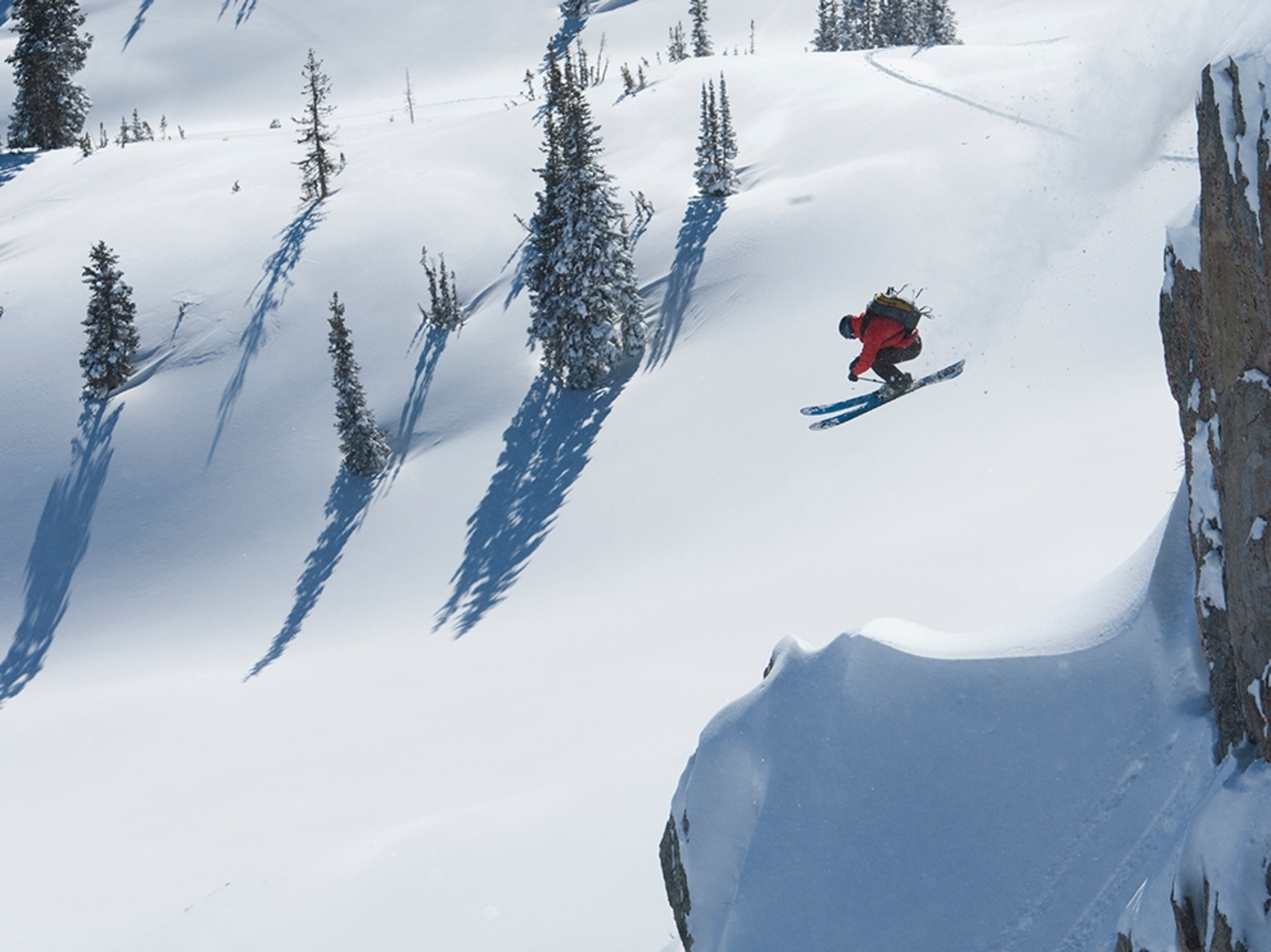 a skier jumping off a big cliff in Alta, Utah.