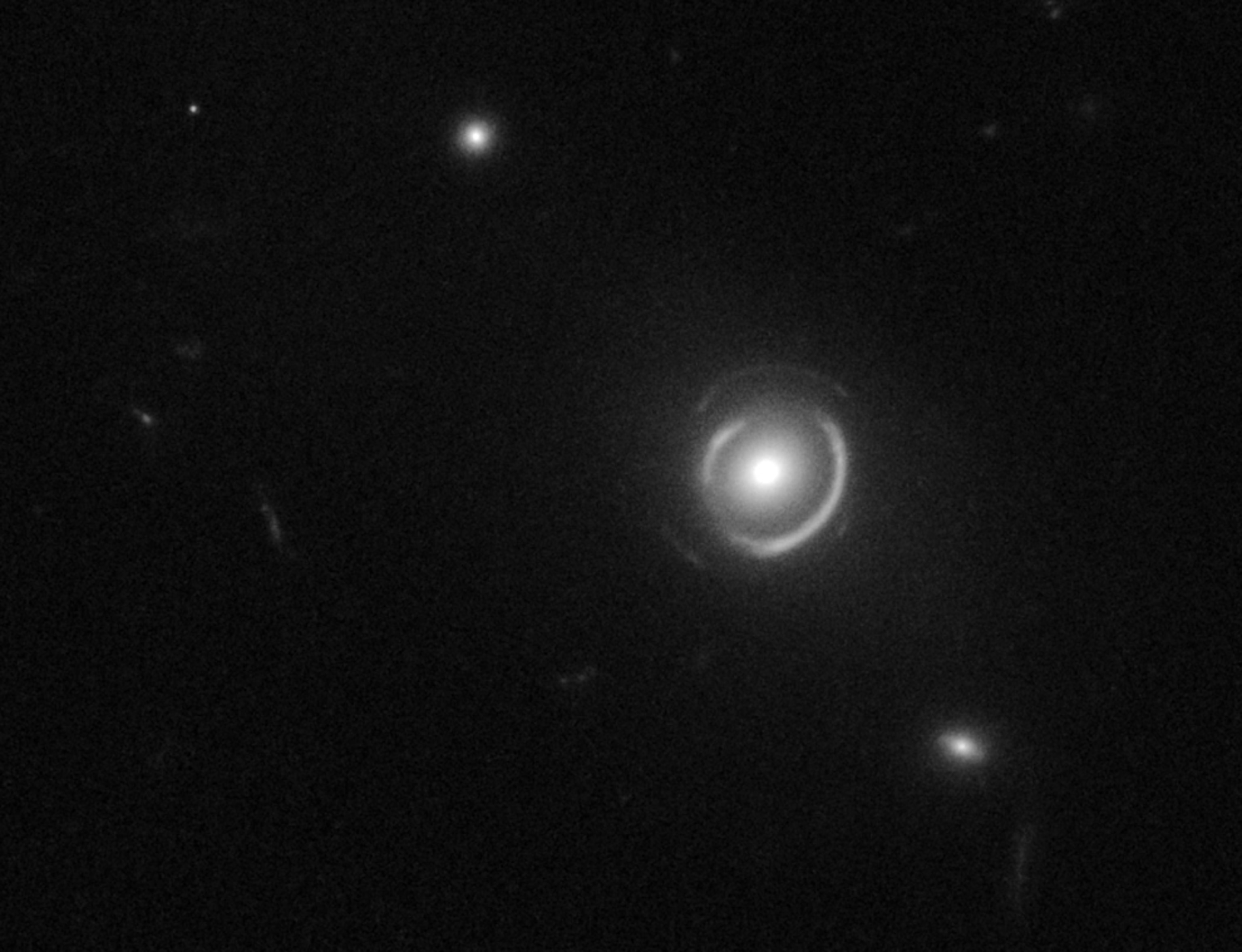 Two Einstein rings, nestled one inside the other, form a pale "bull's-eye" in space.
