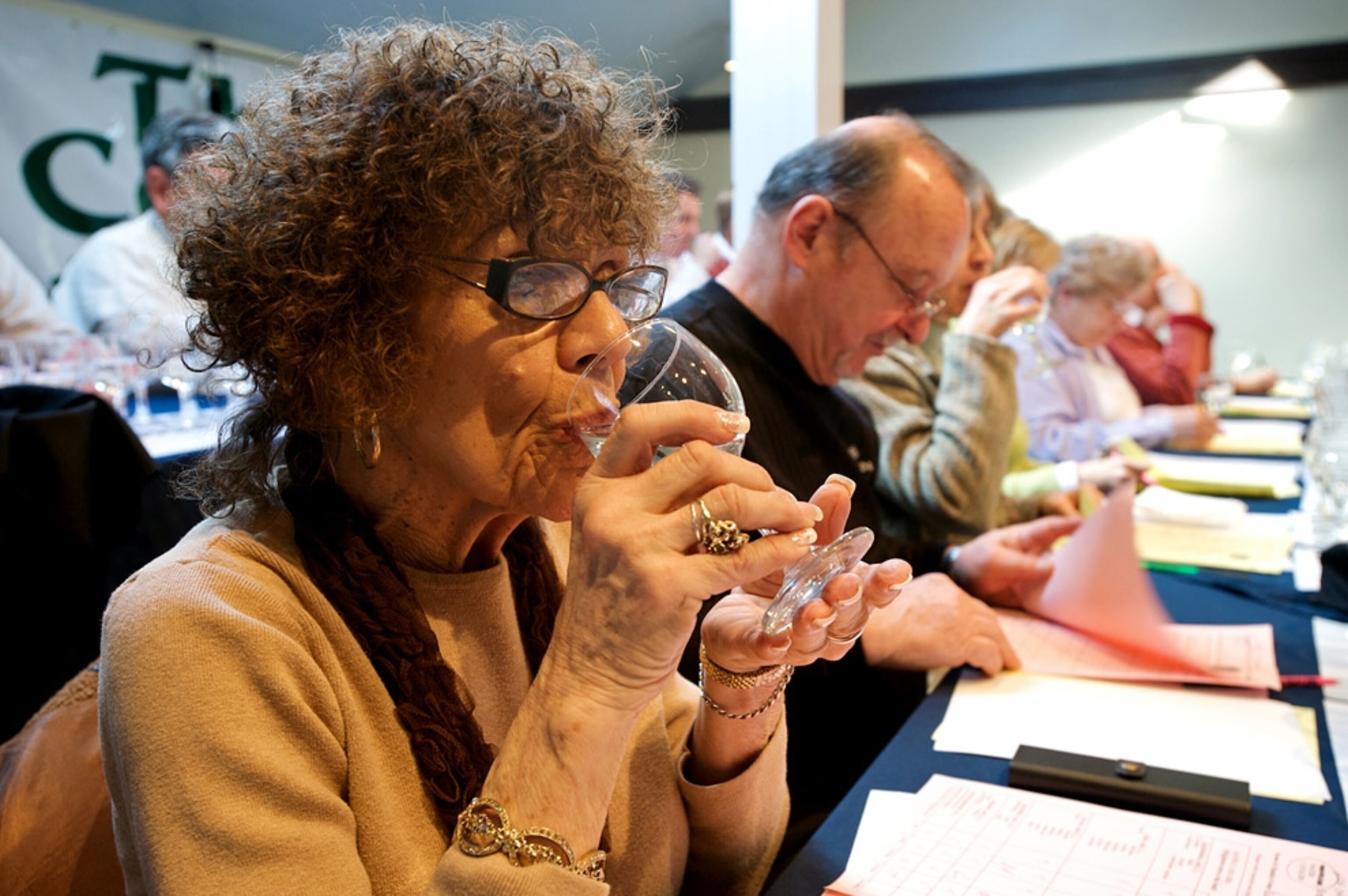 A woman sips a glass of water