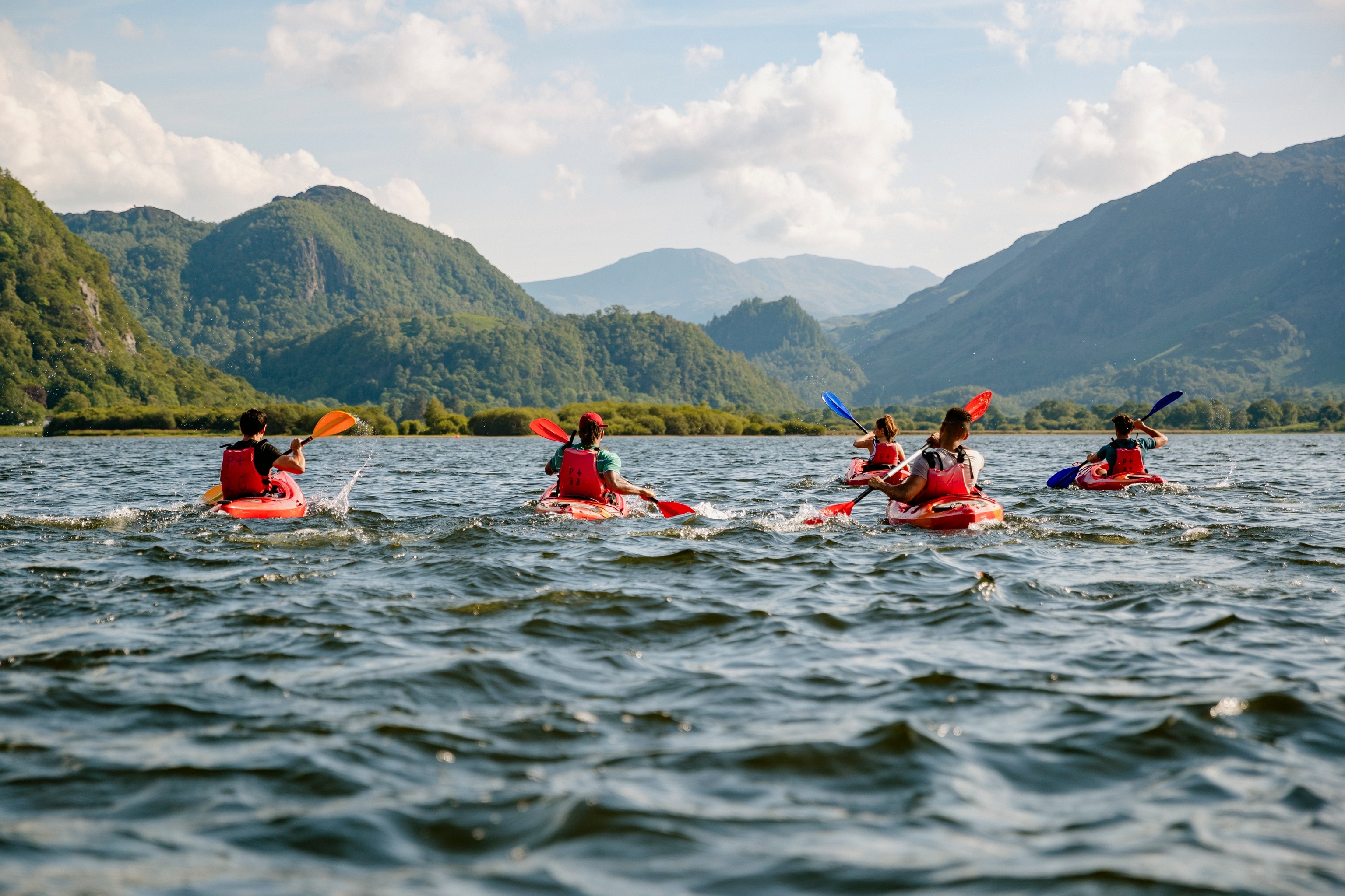 Canoes on a lake surrounded by mountains.