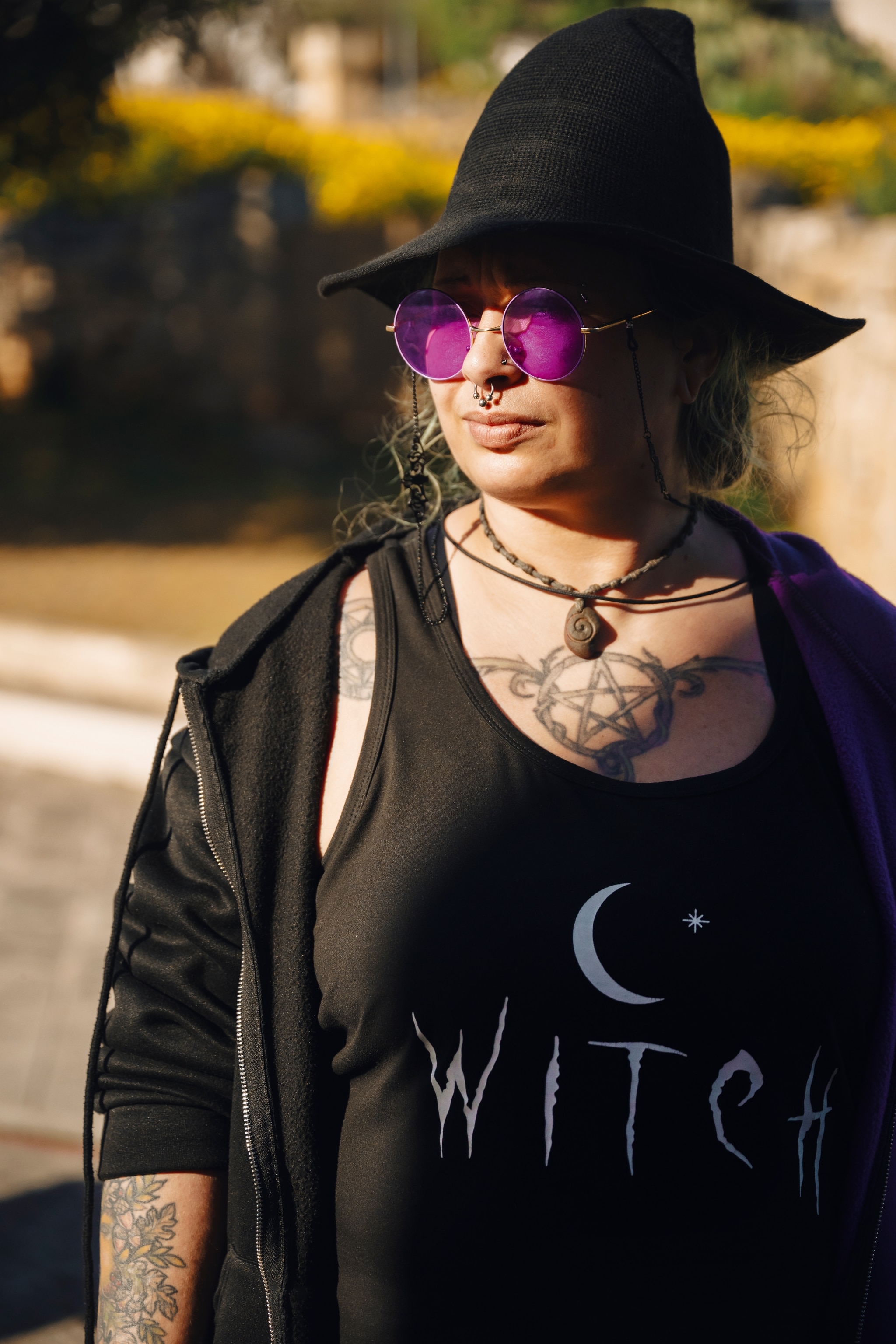 Woman wearing pointy black hat and shirt saying 'witch'