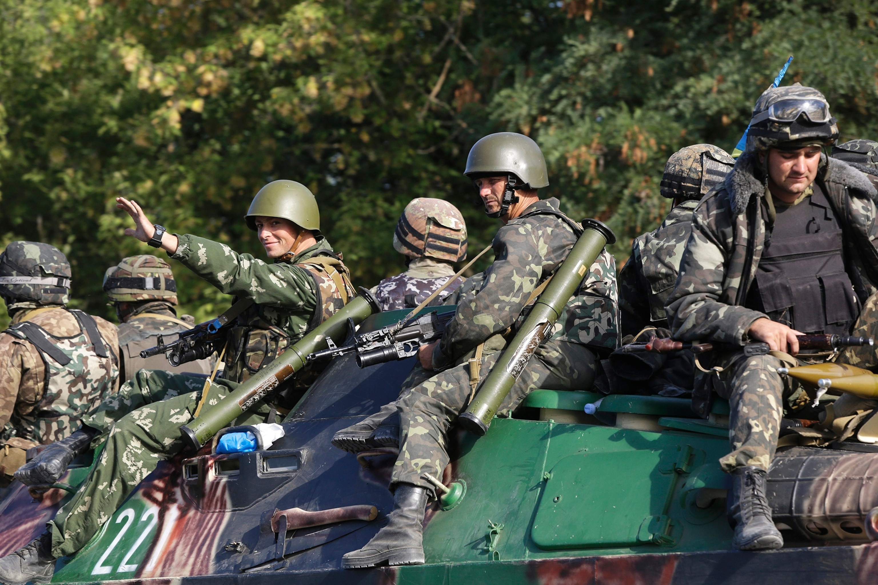 A Ukrainian soldier stands on a tank in a military camp, near the eastern Ukrainian town of Rassypnoe.