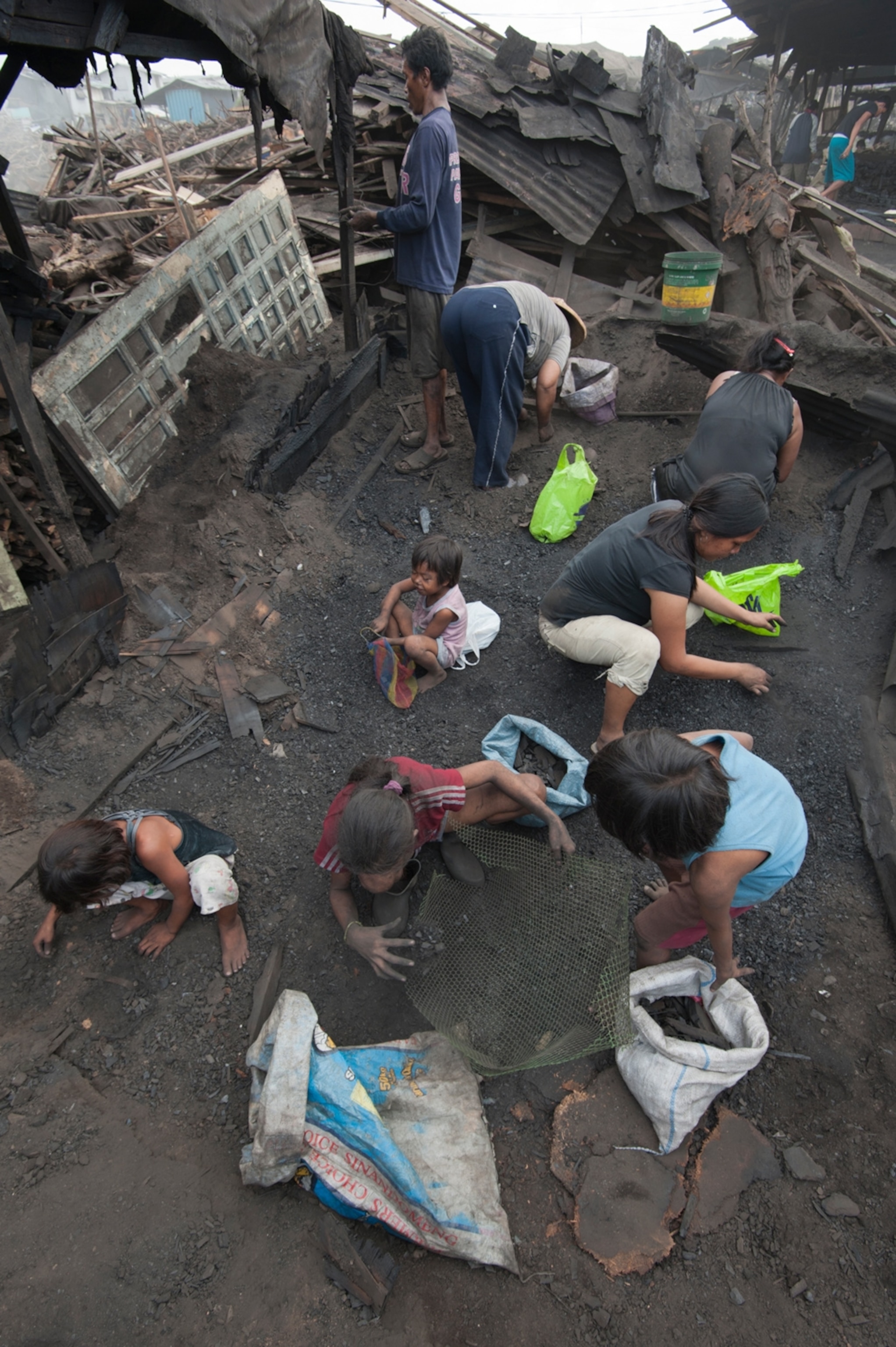 Women and children sift through the ashes, Manila