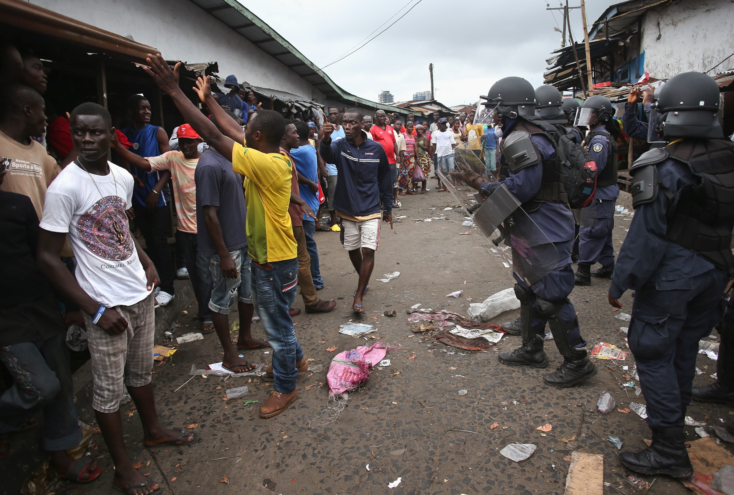 a Liberian health worker disinfecting a corpse after the man died.