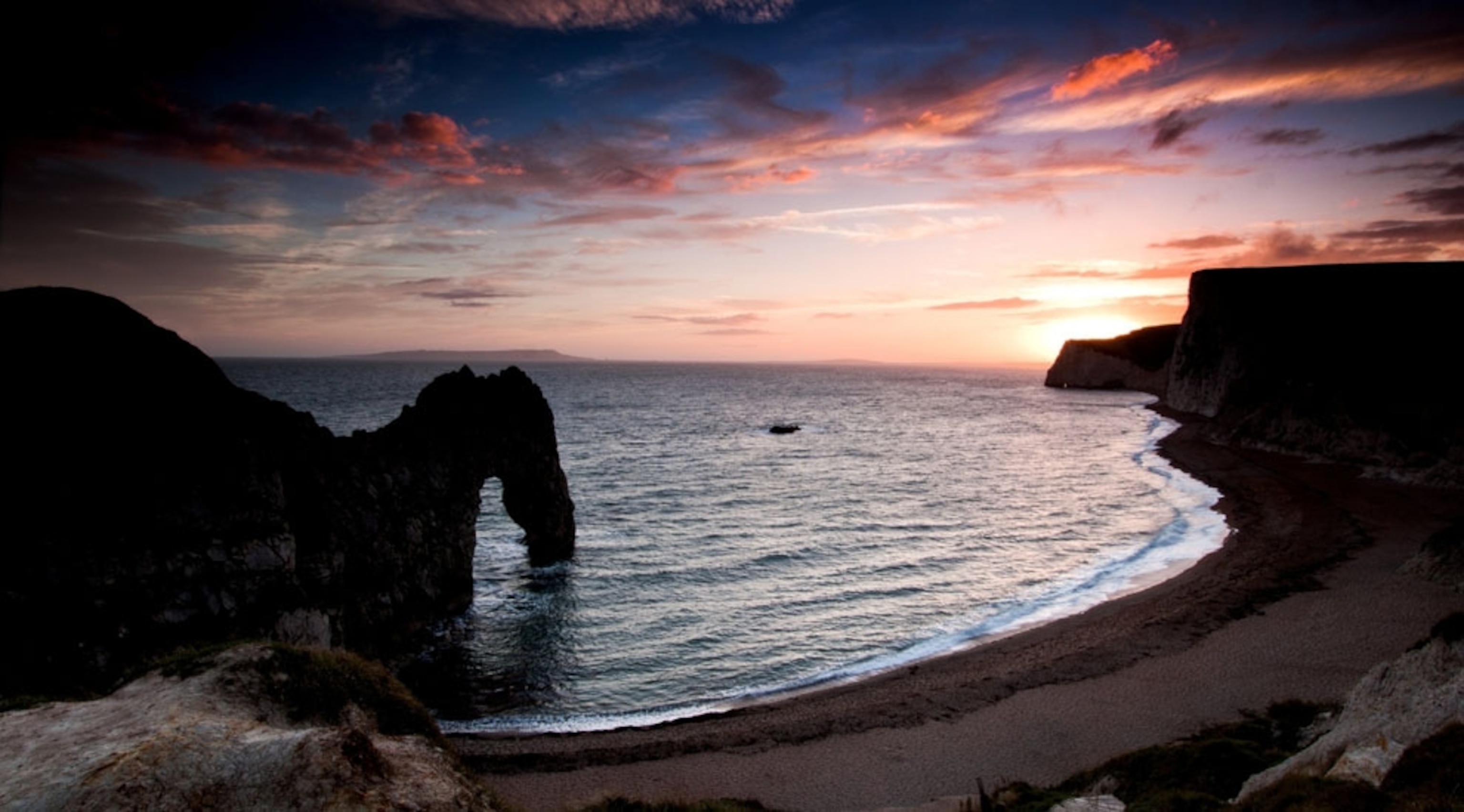 Sun setting over the water of Dorset's Durdle Door