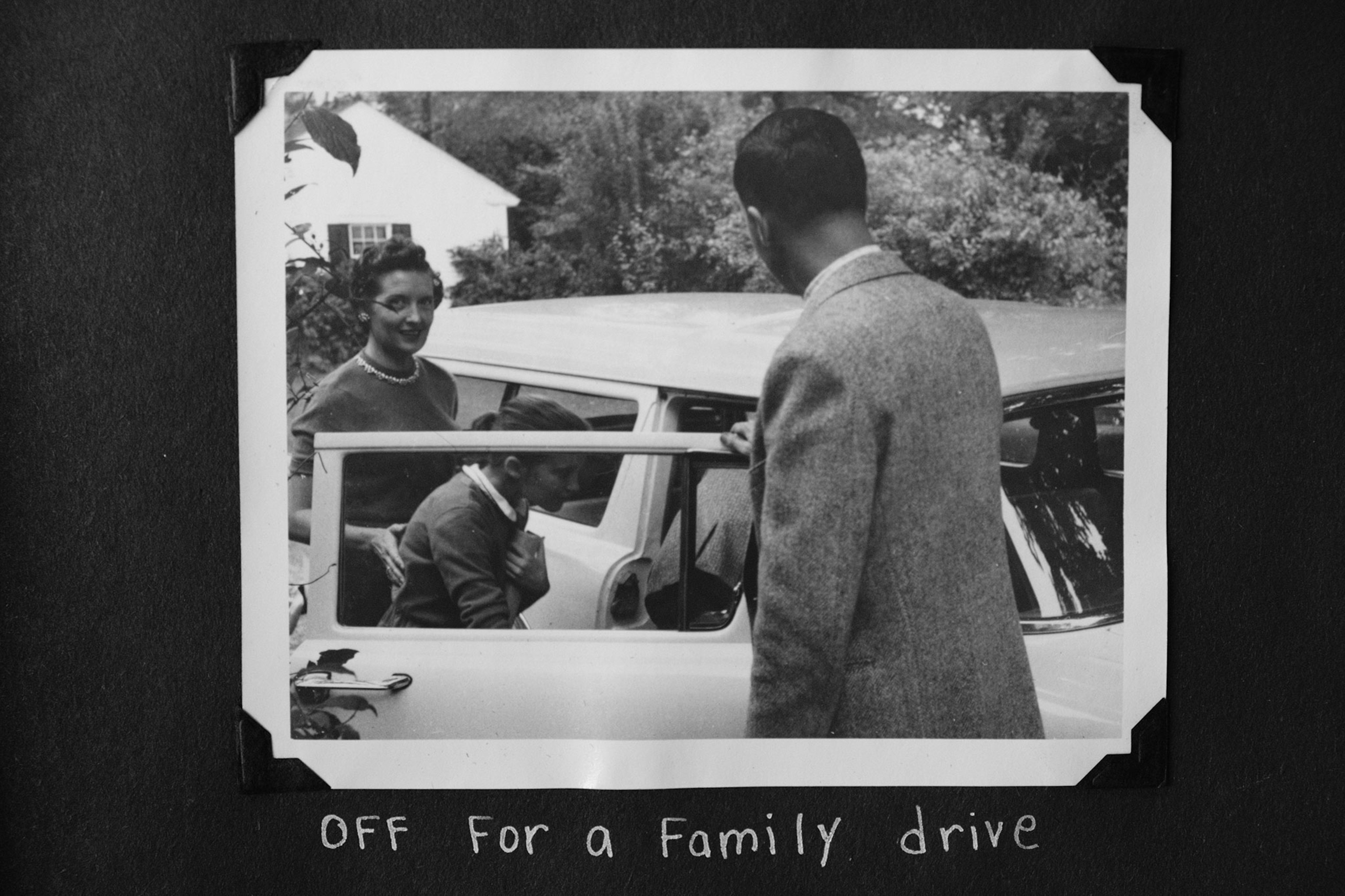 woman standing next to old car