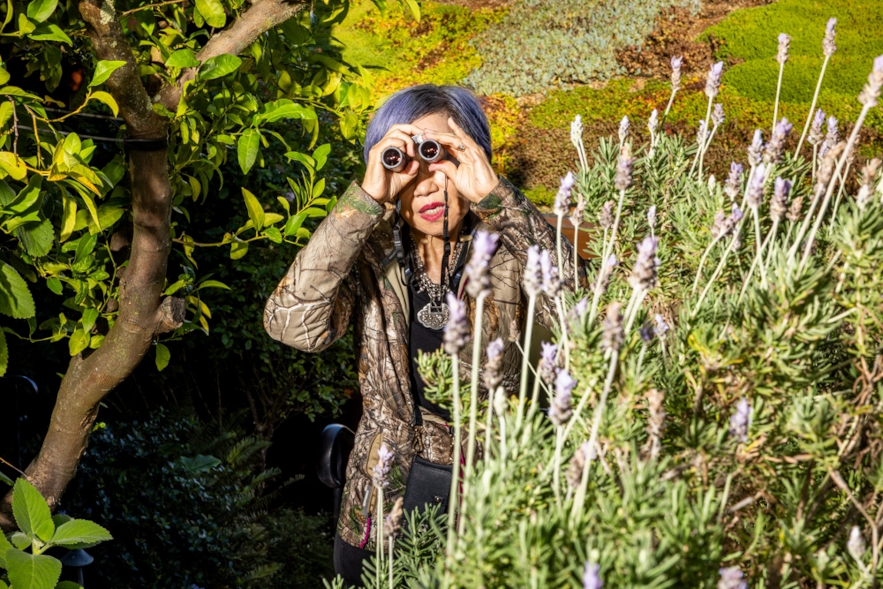 A woman with binoculars looks out into the distance