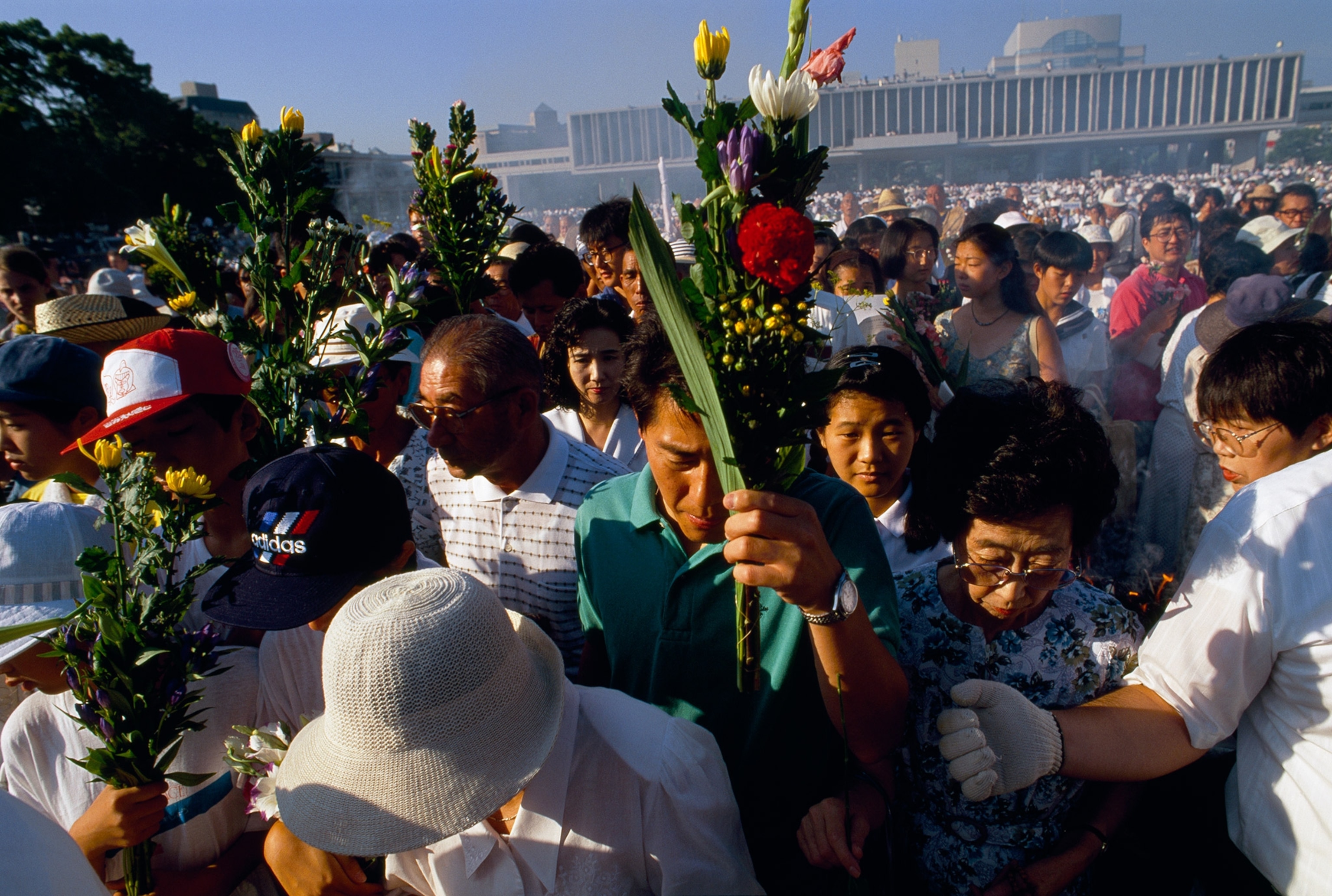 people laying flowers at a ceremony for the people who died from the Atomic Bomb