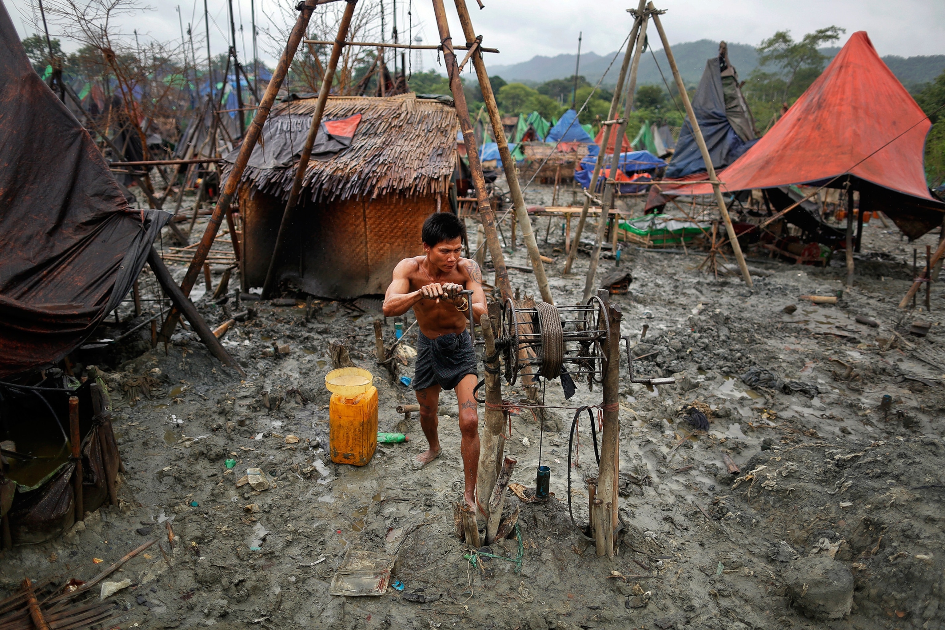 Ko Min, 26 manually extracting oil from one of three 300 feet deep wells he works on in the Minhla township of the Magwe in Myanmar.