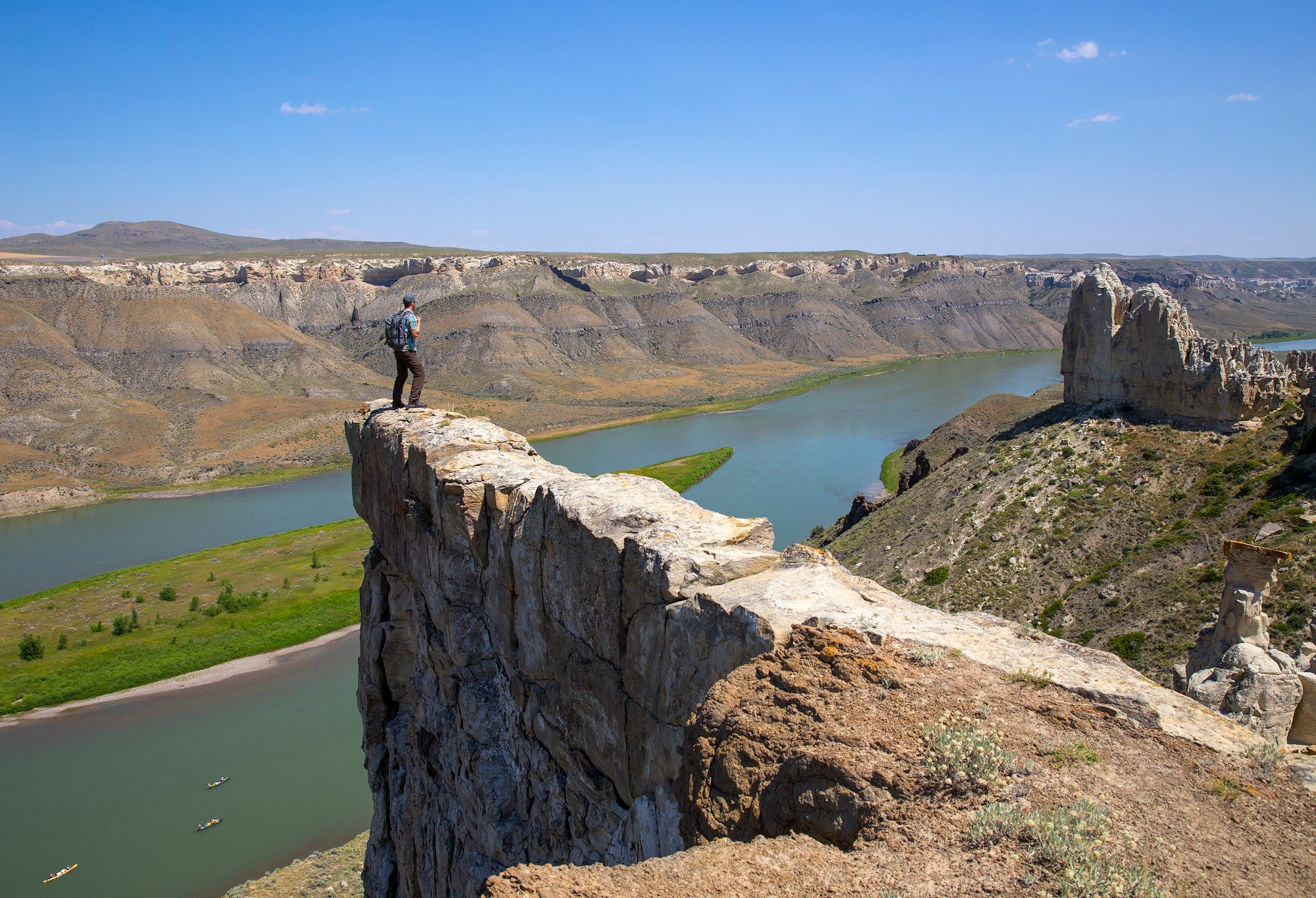 a hiker standing atop a rock formation called Hole in the Wall in central Montana