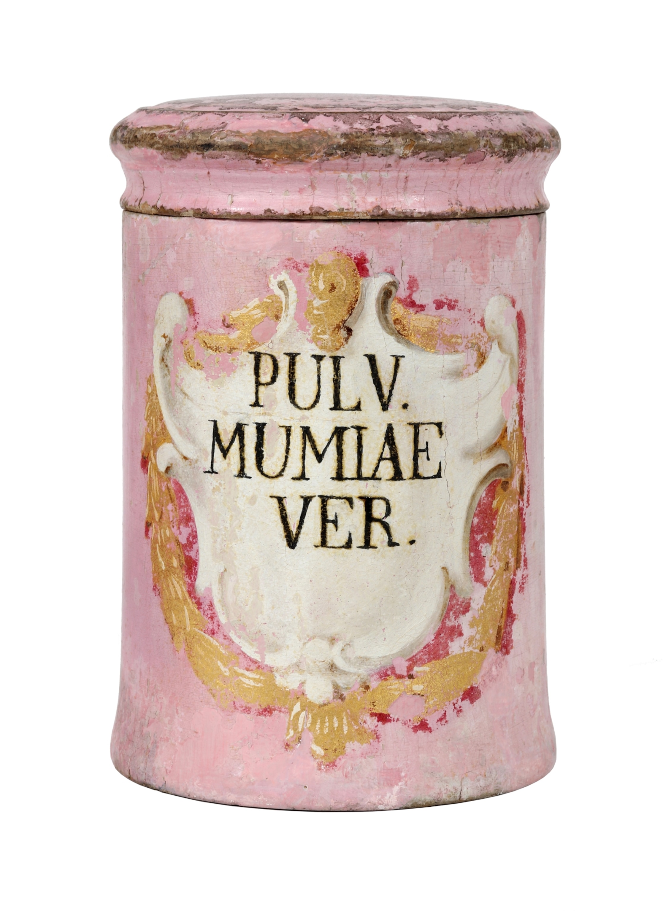 A pink antique pharmacy jar with decorative gold accents is labeled “PULV. MUMIAE VER.” and shown against a plain background.