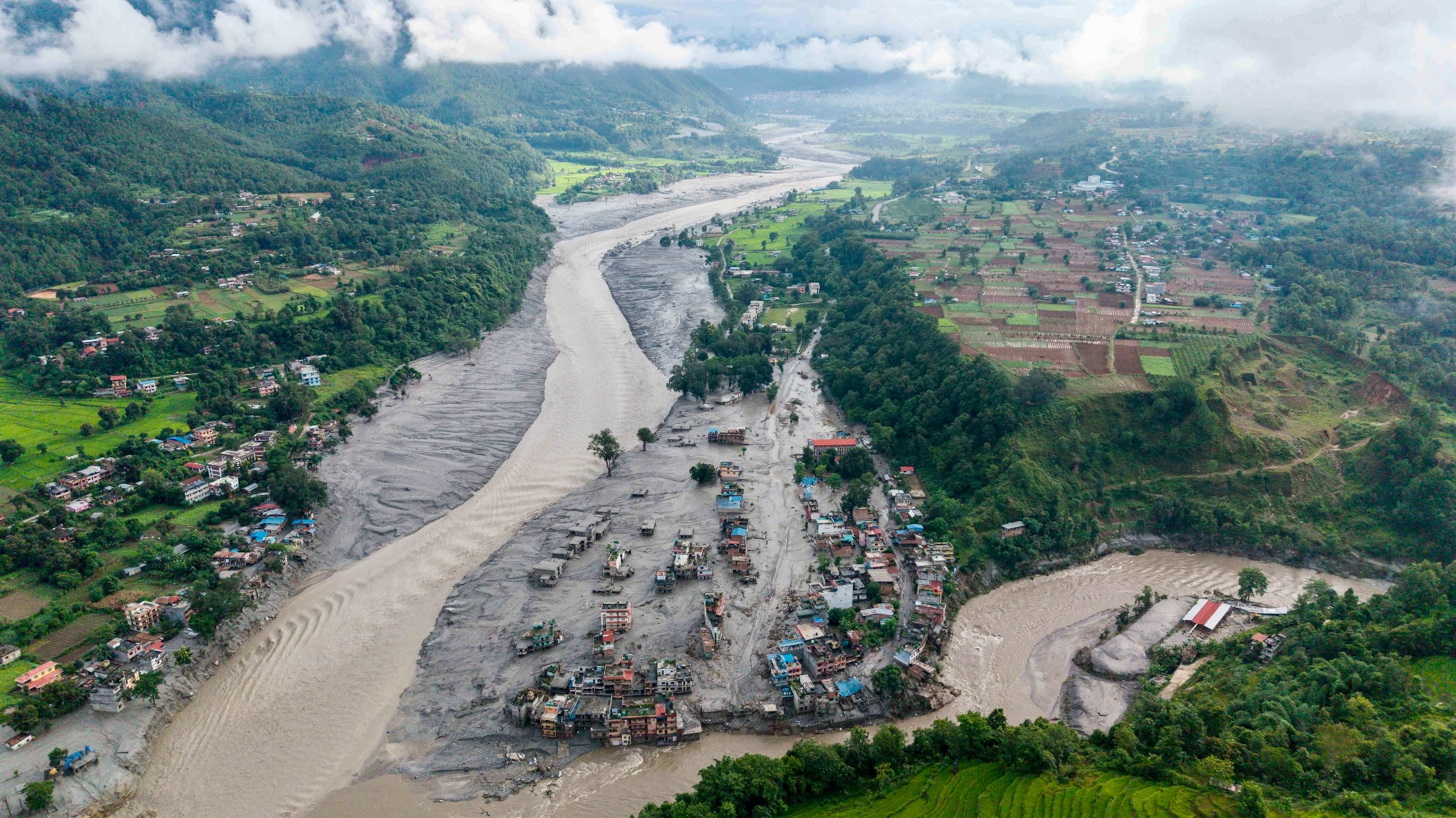 An aerial view shows houses lying deluged in sludge after flash floods at Devighat, Bidur Municipality, along the confluence of the Trishuli and Tadi rivers in Nepal's Nuwakot district.