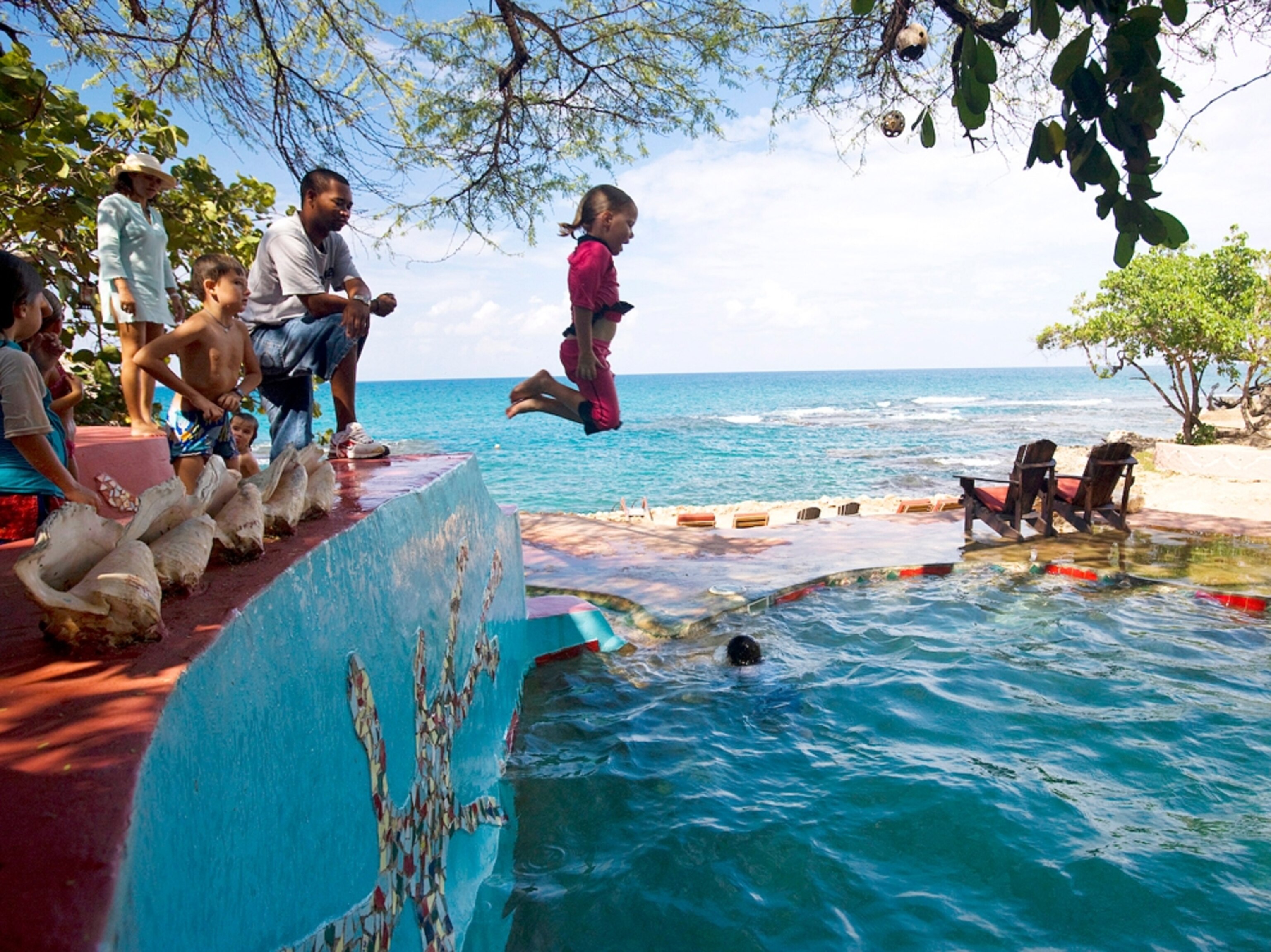 Young girl jumps into pool, Jake's Resort, Calabash Bay, Jamaica