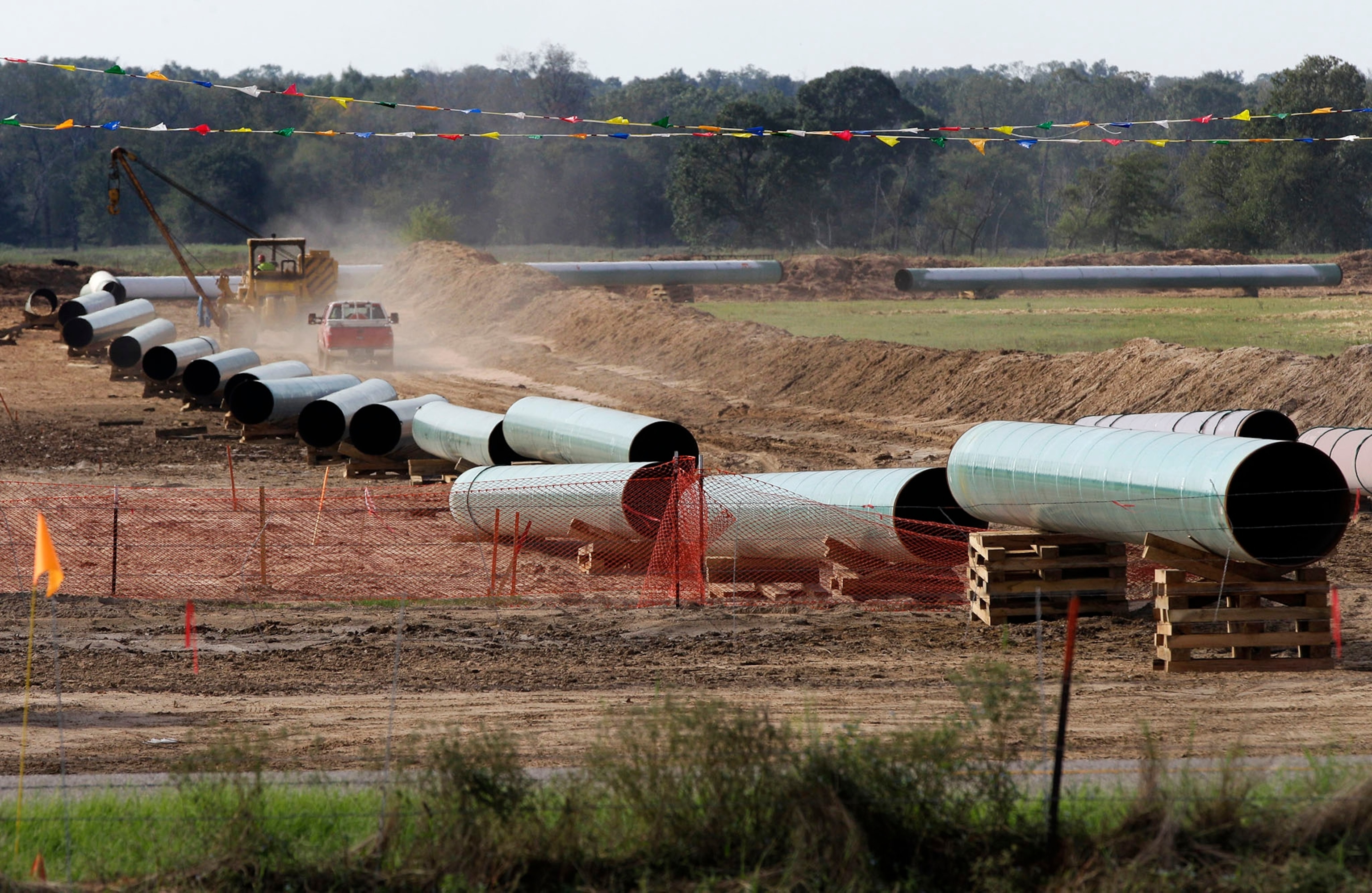 In the is Oct. 4, 2012 file photo, large sections of pipe are shown on a neighboring property to Julia Trigg Crawford family farm, in Sumner Texas. On Wednesday, Jan 22, 2014, TransCanada said in a statement on its website that it is delivering oil through the Gulf Coast portion of its proposed Keystone XL pipeline, from a hub in Cushing, Okla., to Houston-area refineries. (AP Photo/Tony Gutierrez, file)