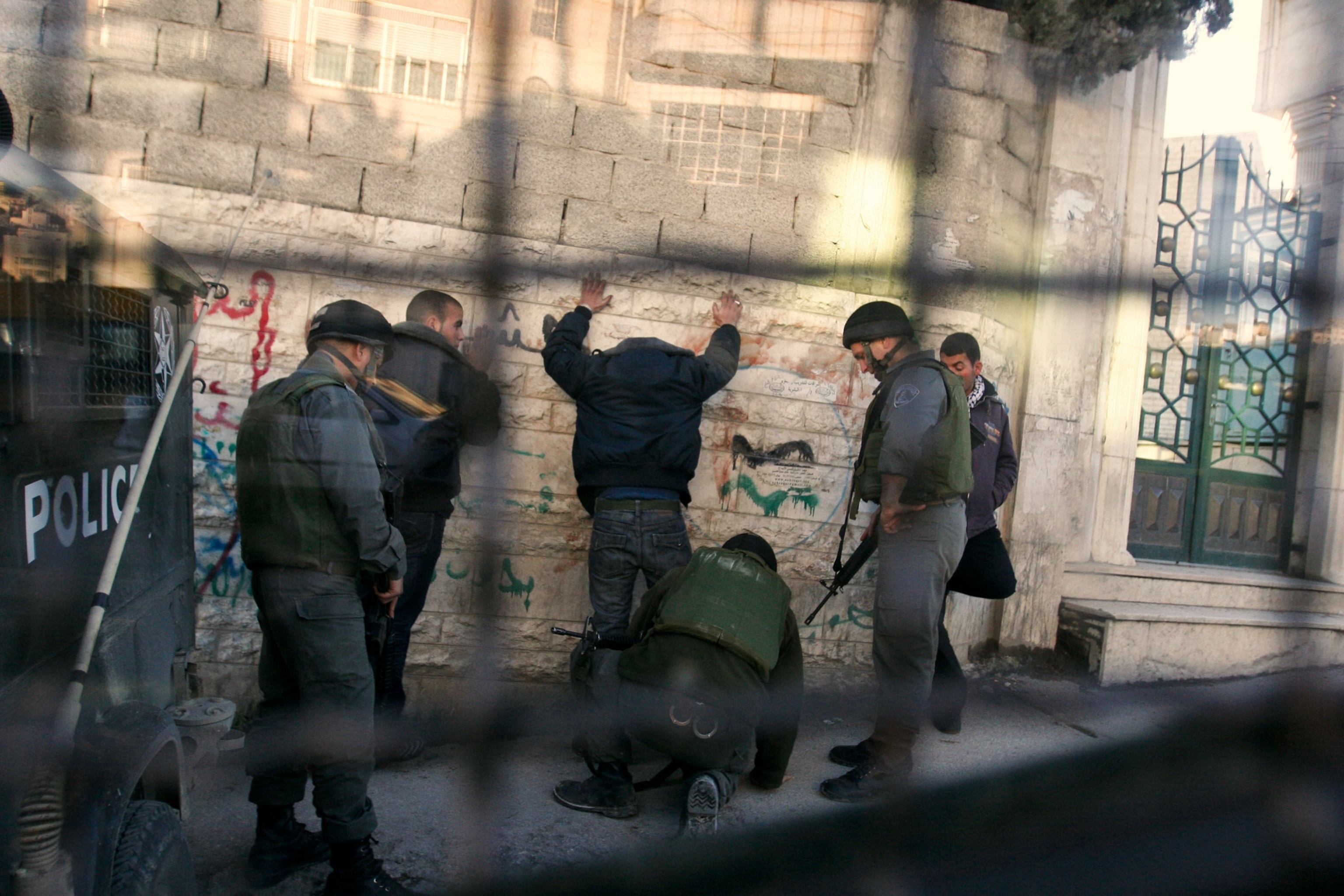 Israeli border police search Palestinians in Hebron, West Bank.