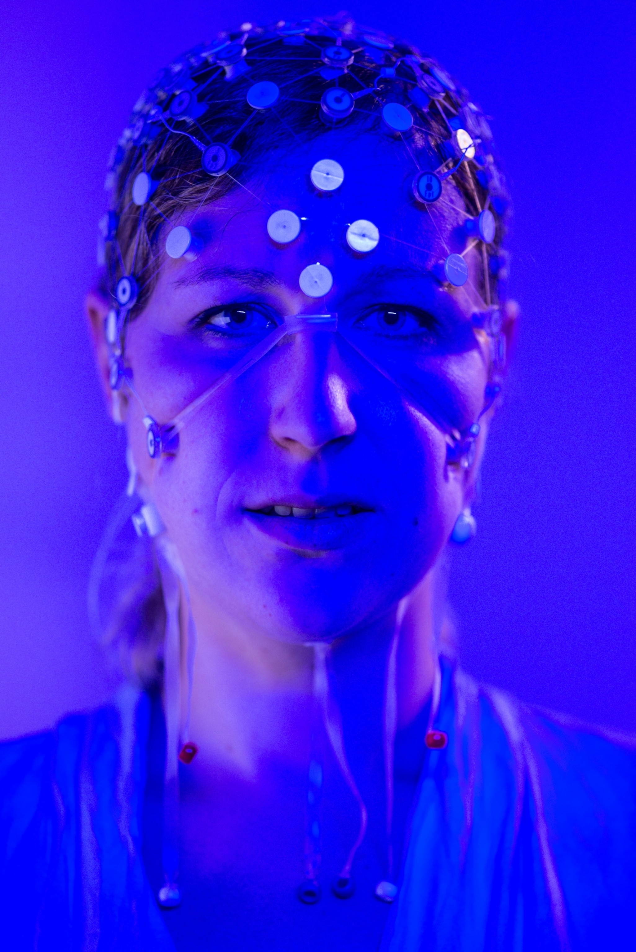 A woman's head, which is covered by a layer of electrodes to read her brain activity.