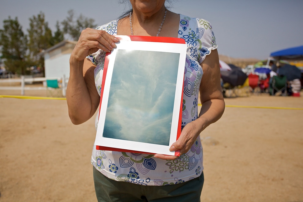 A woman holding up a large photograph