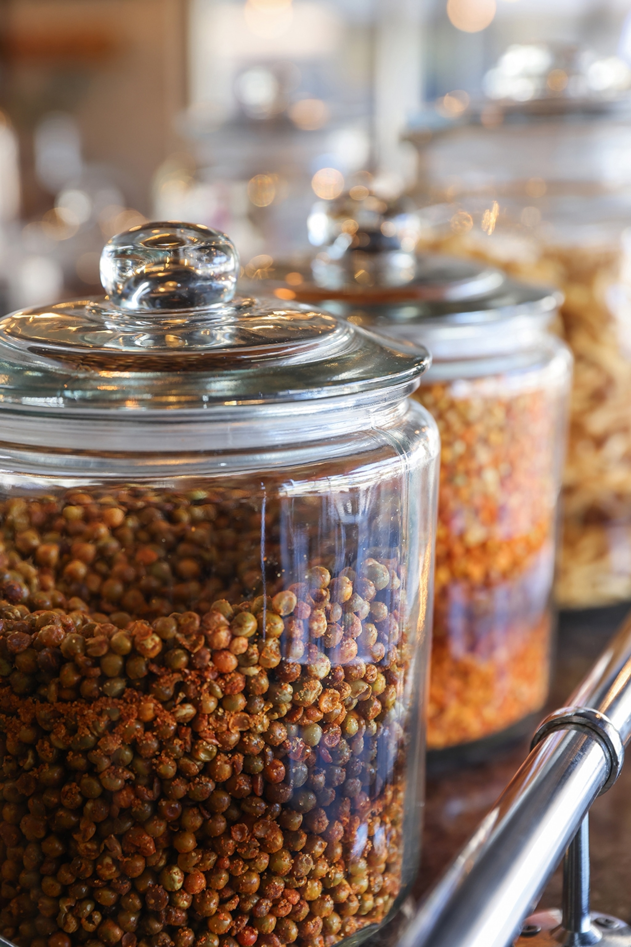 A close-up on big jars filled with masala-spiced peanuts.