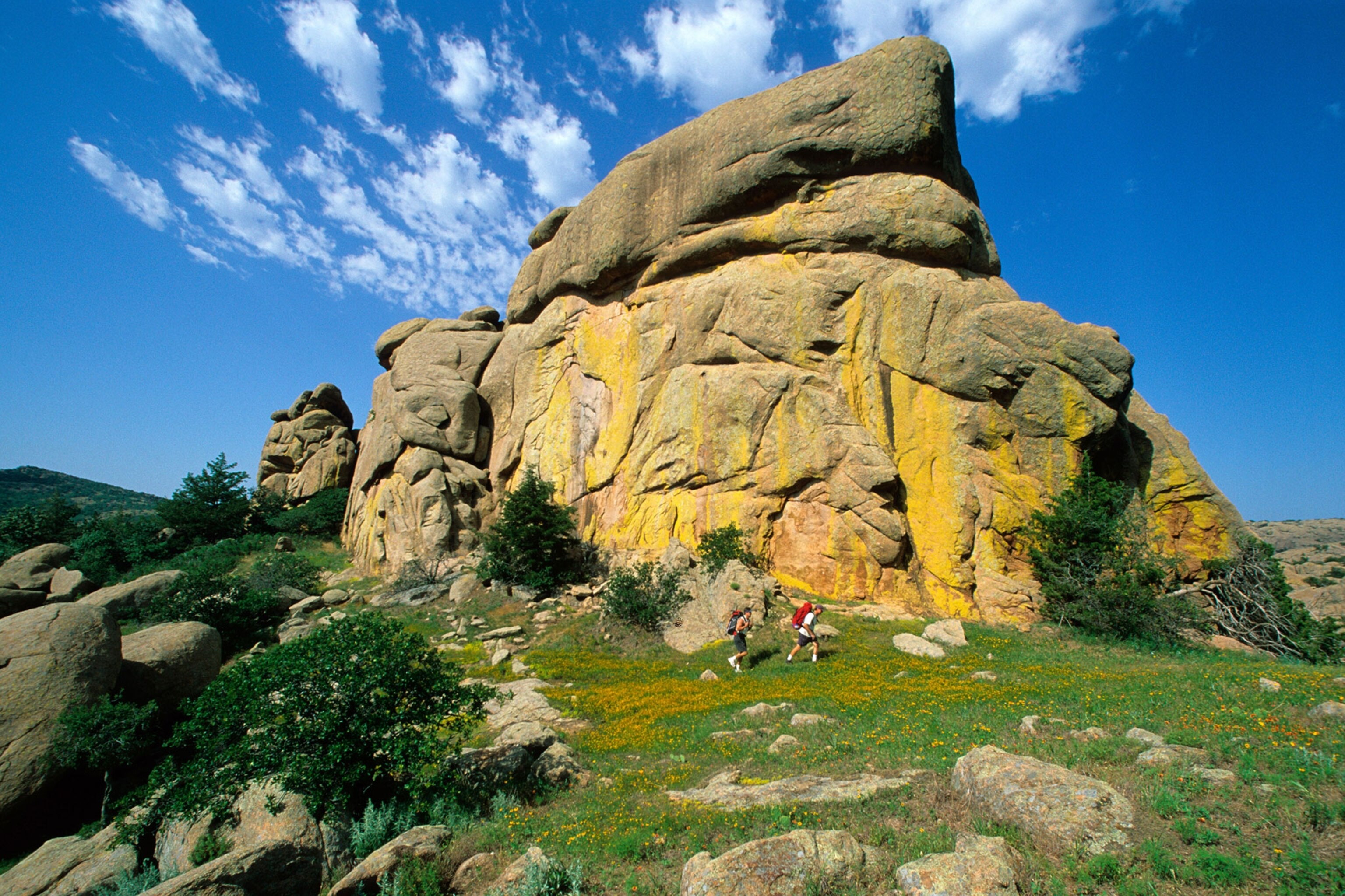 hikers below colorful granite dome in the Wichita Wildlife Refuge near Lawton, Oklahoma