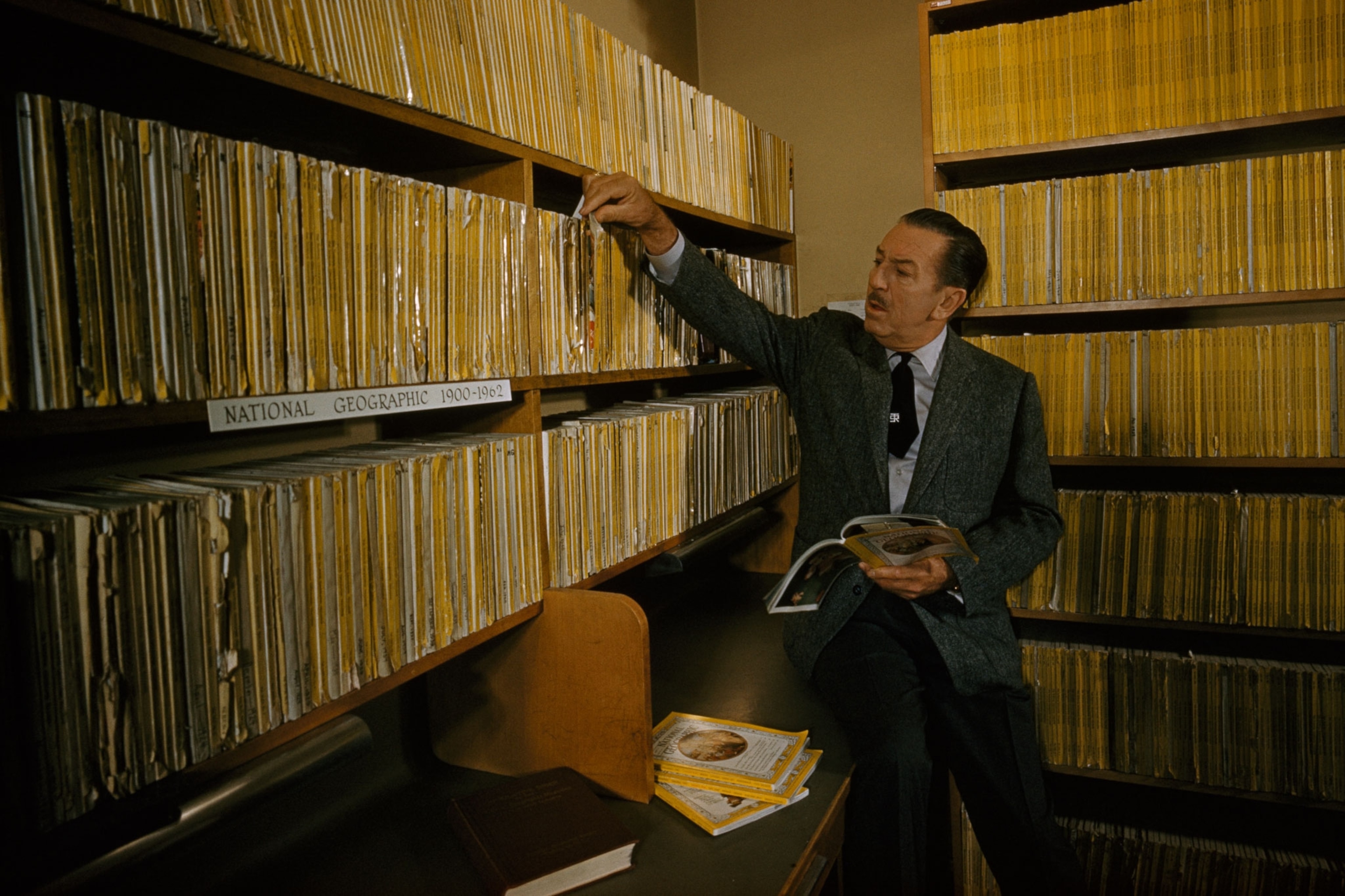 Walt Disney looking at National Geographic Magazines