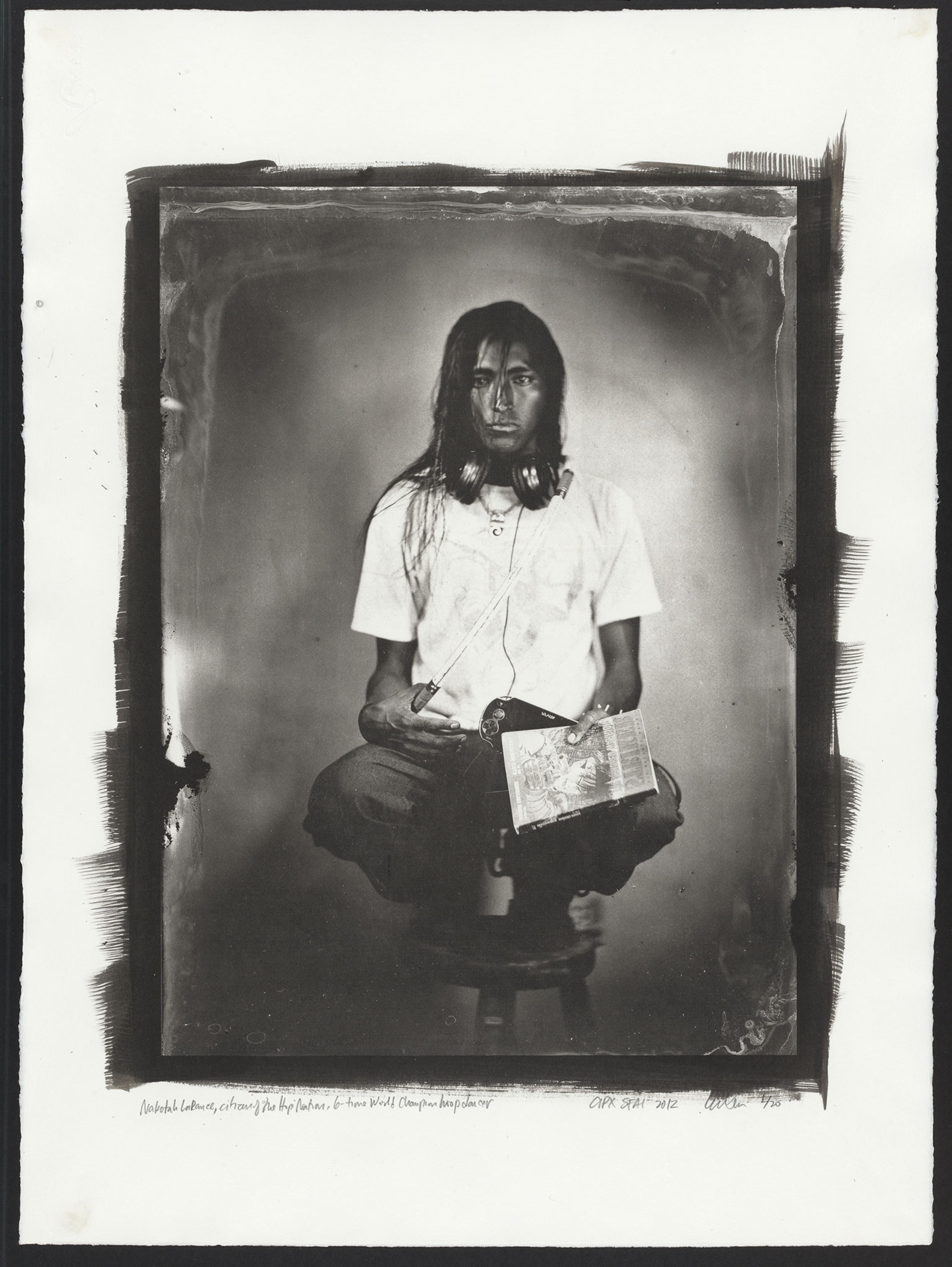 Nakotah LaRance, Citizen of the Hopi Nation, 6-Time World Champion Hoop Dancer, equipped with a game console, earphones, and a Japanese graphic novel, with a dance hoop slung across his body