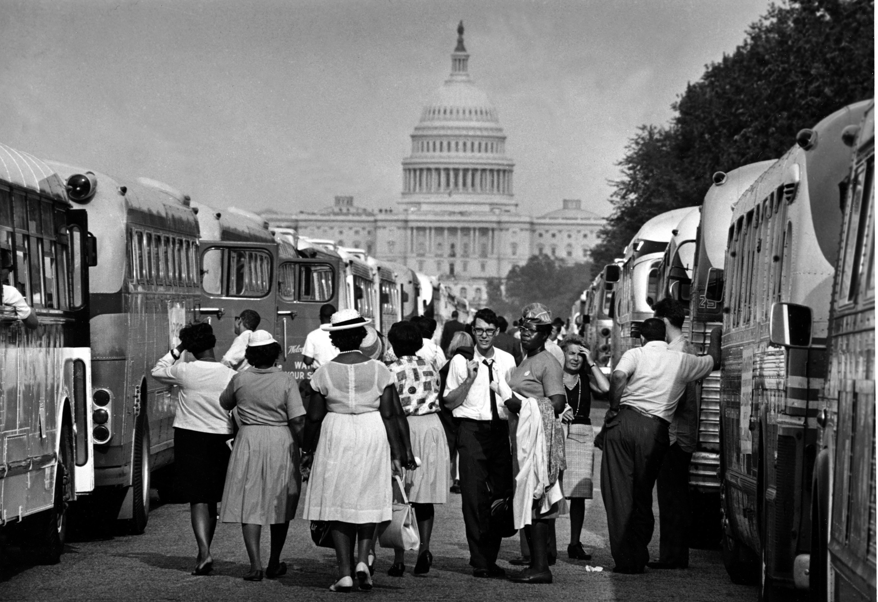 With the U.S. Capitol in the background, passengers for charter busses walk along a service roadway of the Mall in Washington, August 28, 1963, to find their transportation home after a civil rights demonstration estimated by police at more than 200,000 people. (AP Photo)