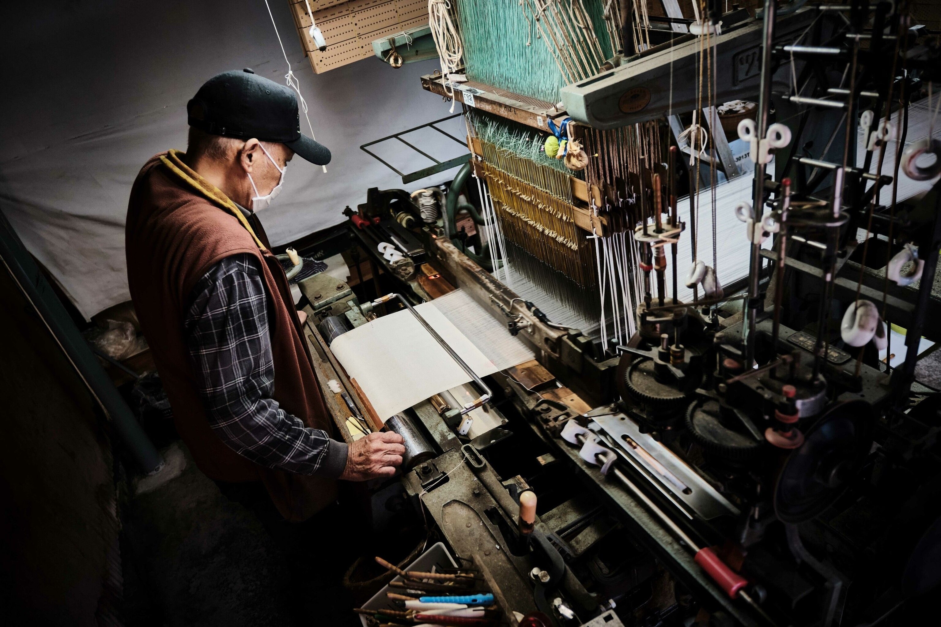 A man using a large machine to process silk.