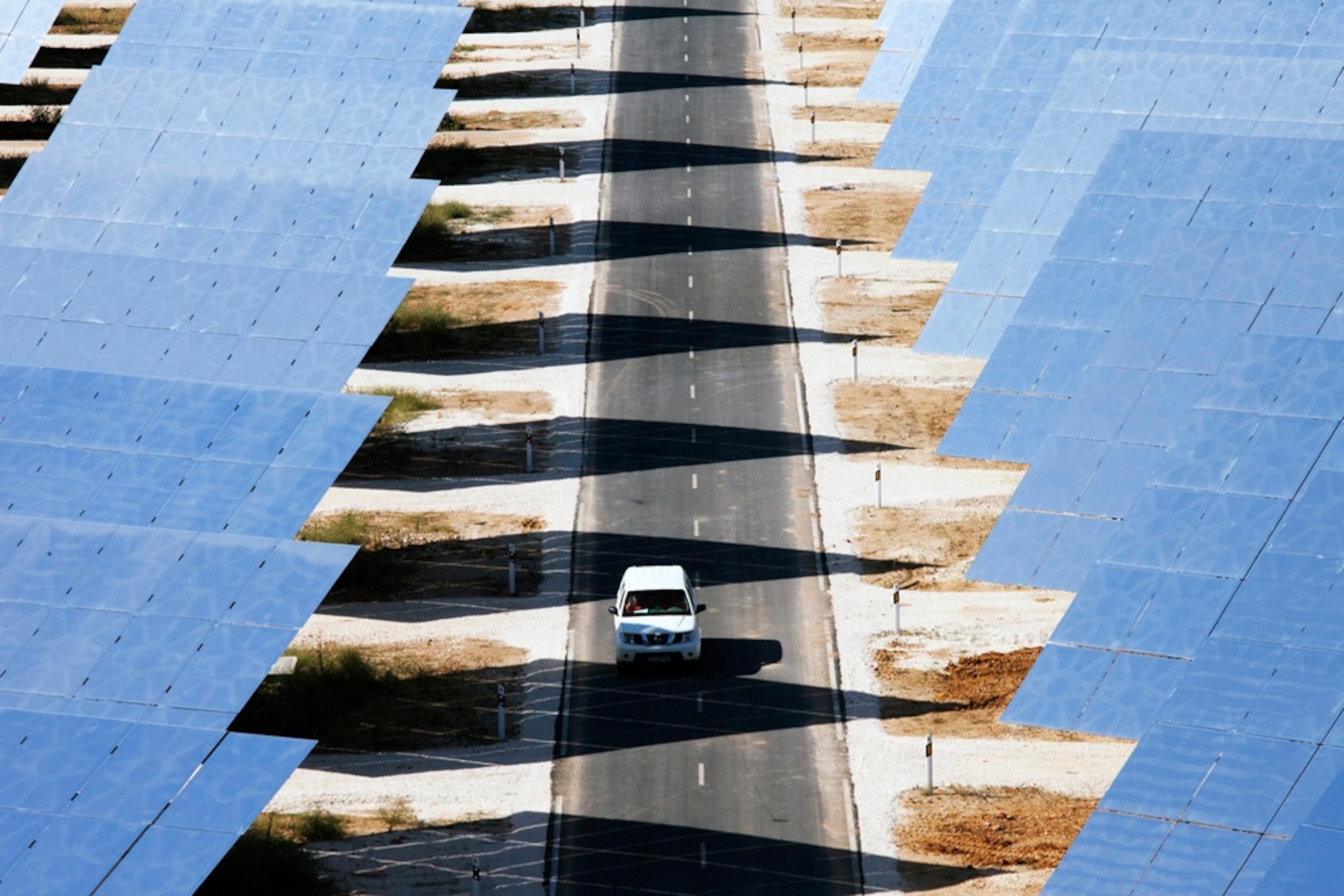 Van drives among solar panels at Gemasolar in Spain