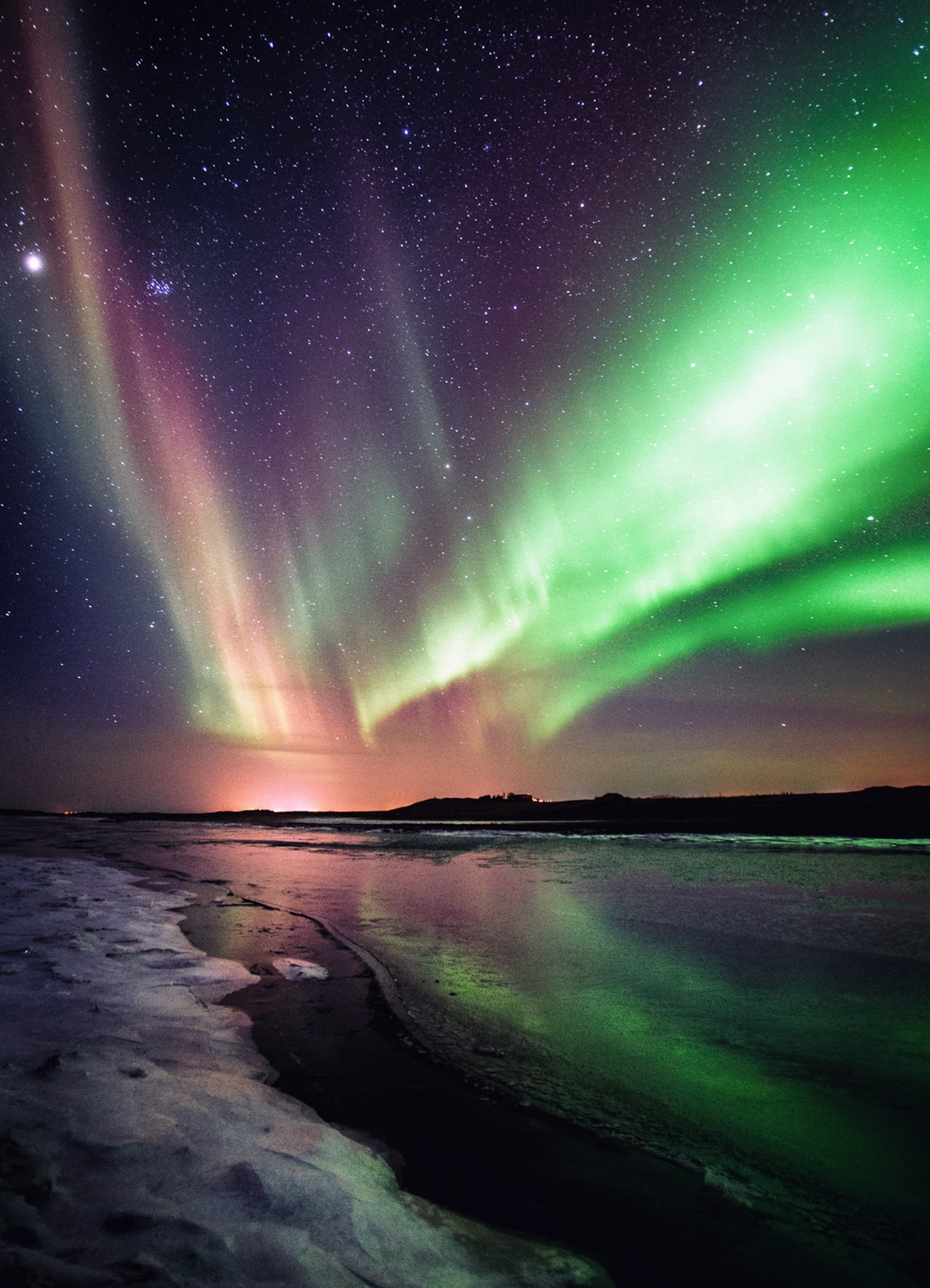 the aurora borealis over a frozen river in Iceland