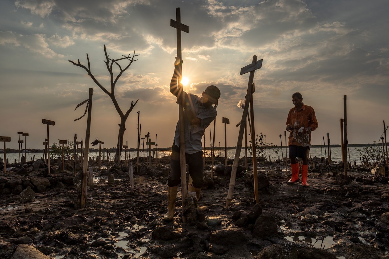 Villagers mark the location of flooded tombstones.