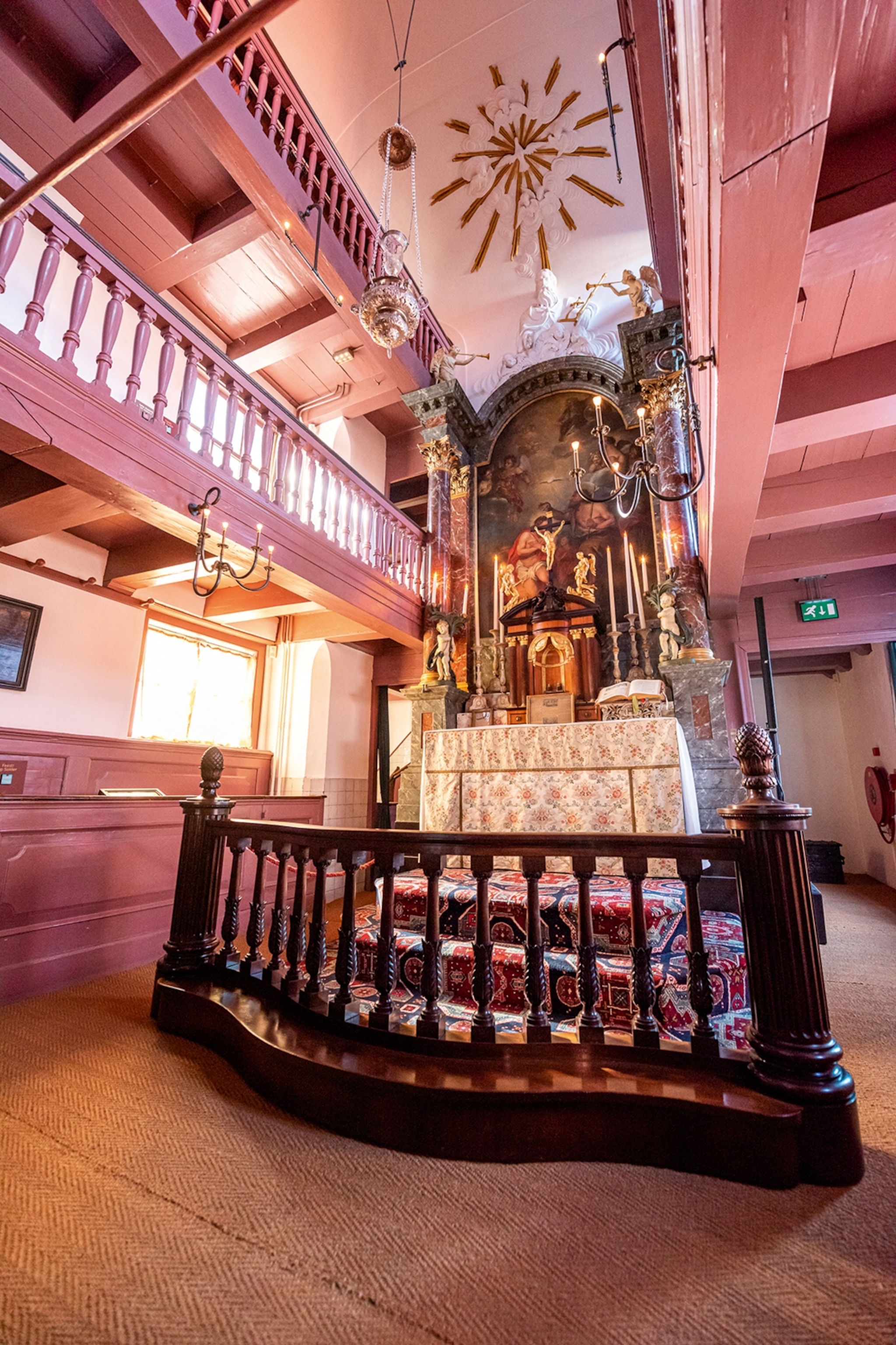 The interior of a small church with a decorated altar in the middle.