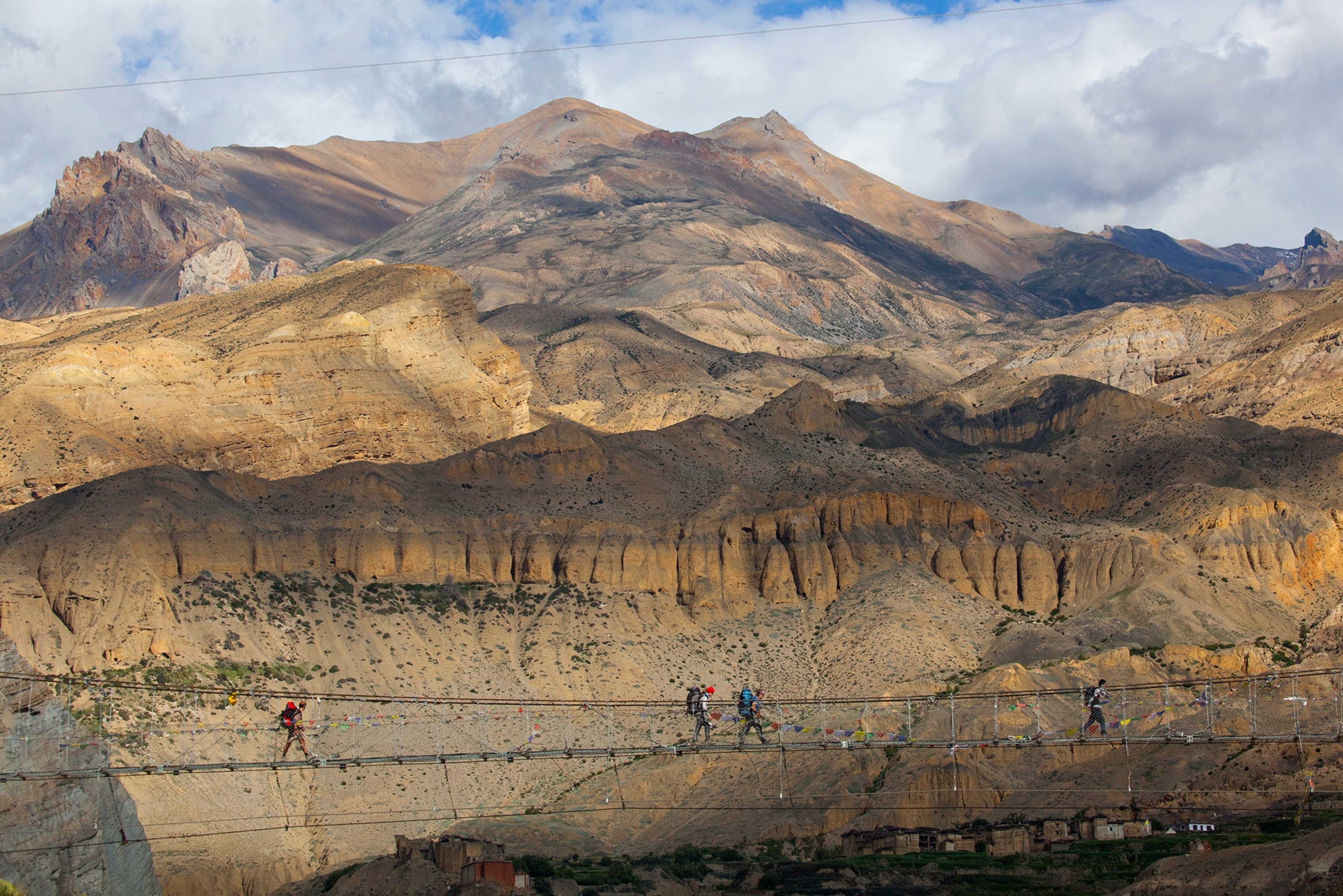 people walking on a suspension bridge on Nepal's Annapurna Circuit