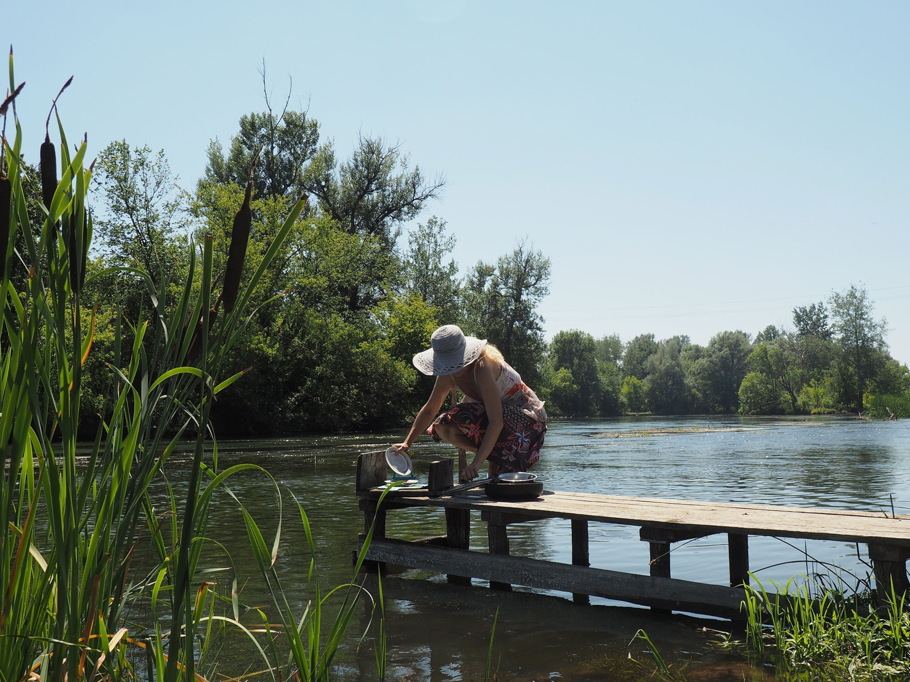 A woman doing dishes in a river in Ukraine