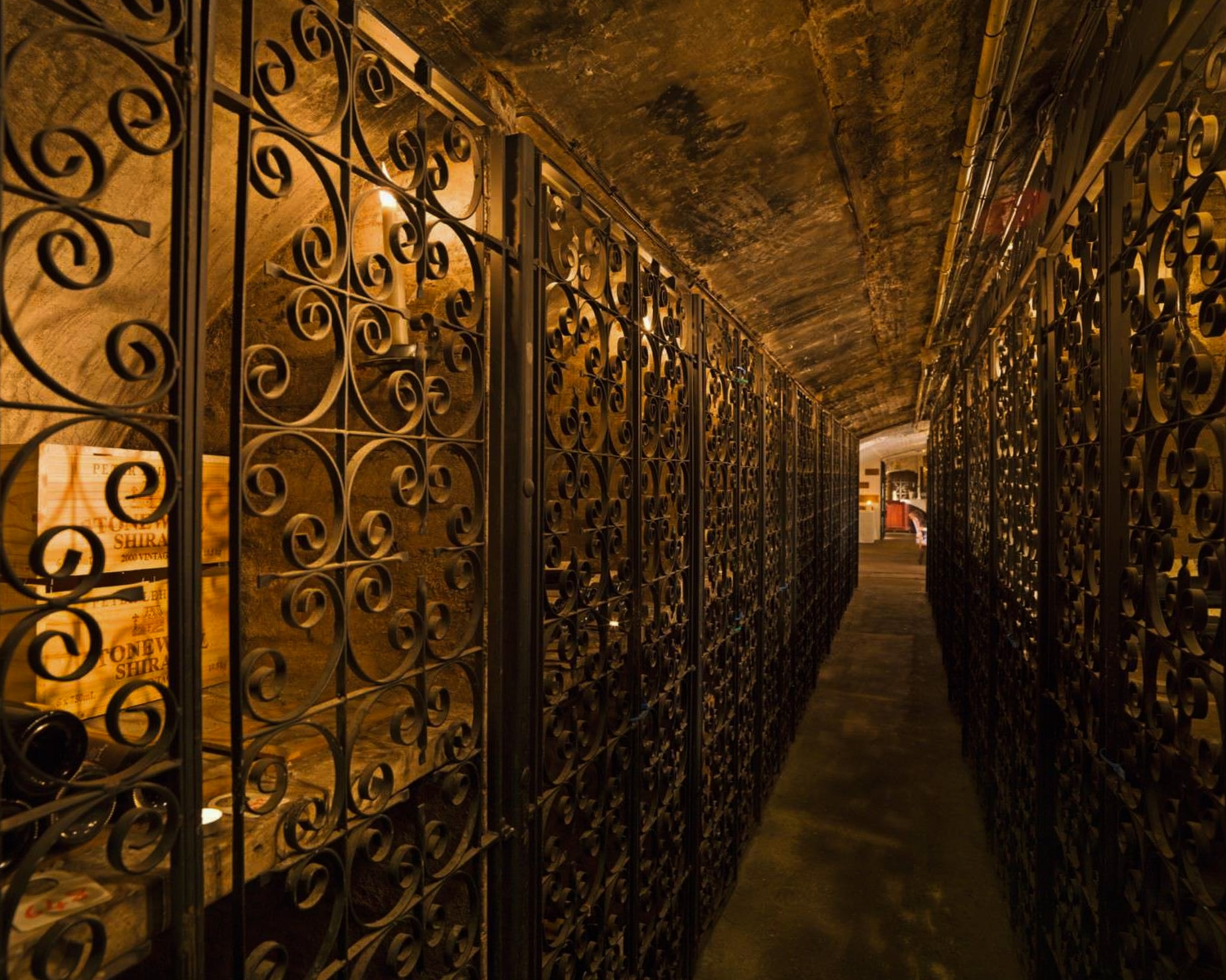 Metal grates on either side of a long hallway in the wine cellar of the Stafford hotel in London.
