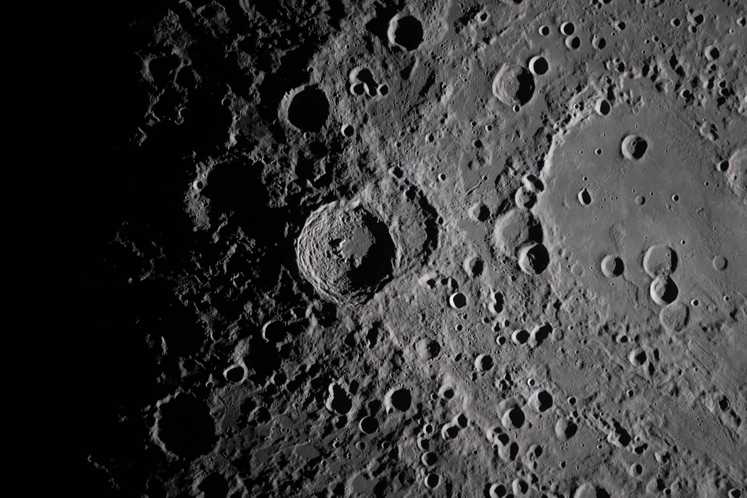 A close-up view taken by the Artemis II crew of Vavilov Crater on the rim of the older and larger Hertzsprung basin. The right portion of the image shows the transition from smooth material within an inner ring of mountains to more rugged terrain around the rim. Vavilov and other craters and their ejecta are accentuated by long shadows at the terminator, the boundary between lunar day and night.