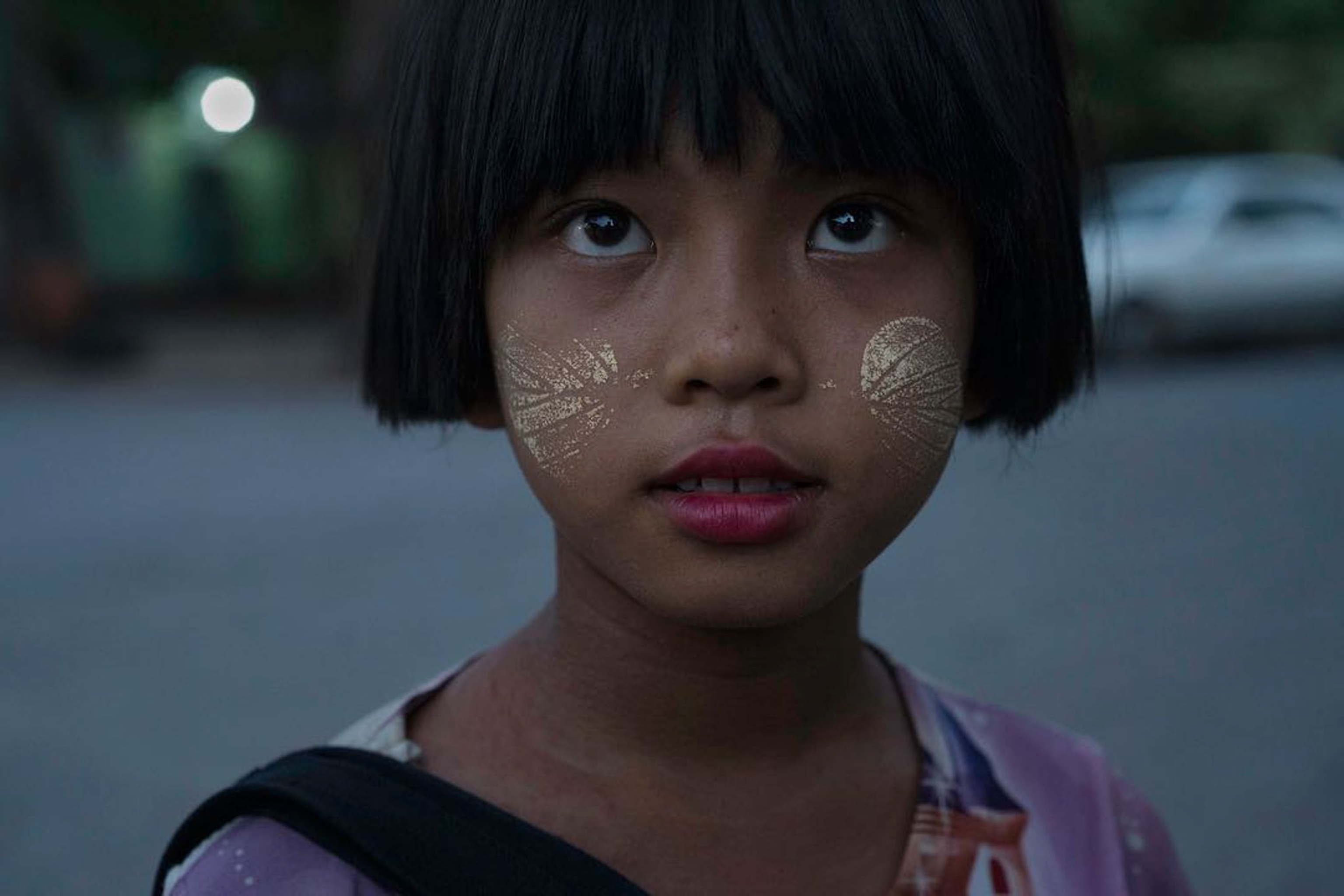 a young girl selling postcards in Myanmar